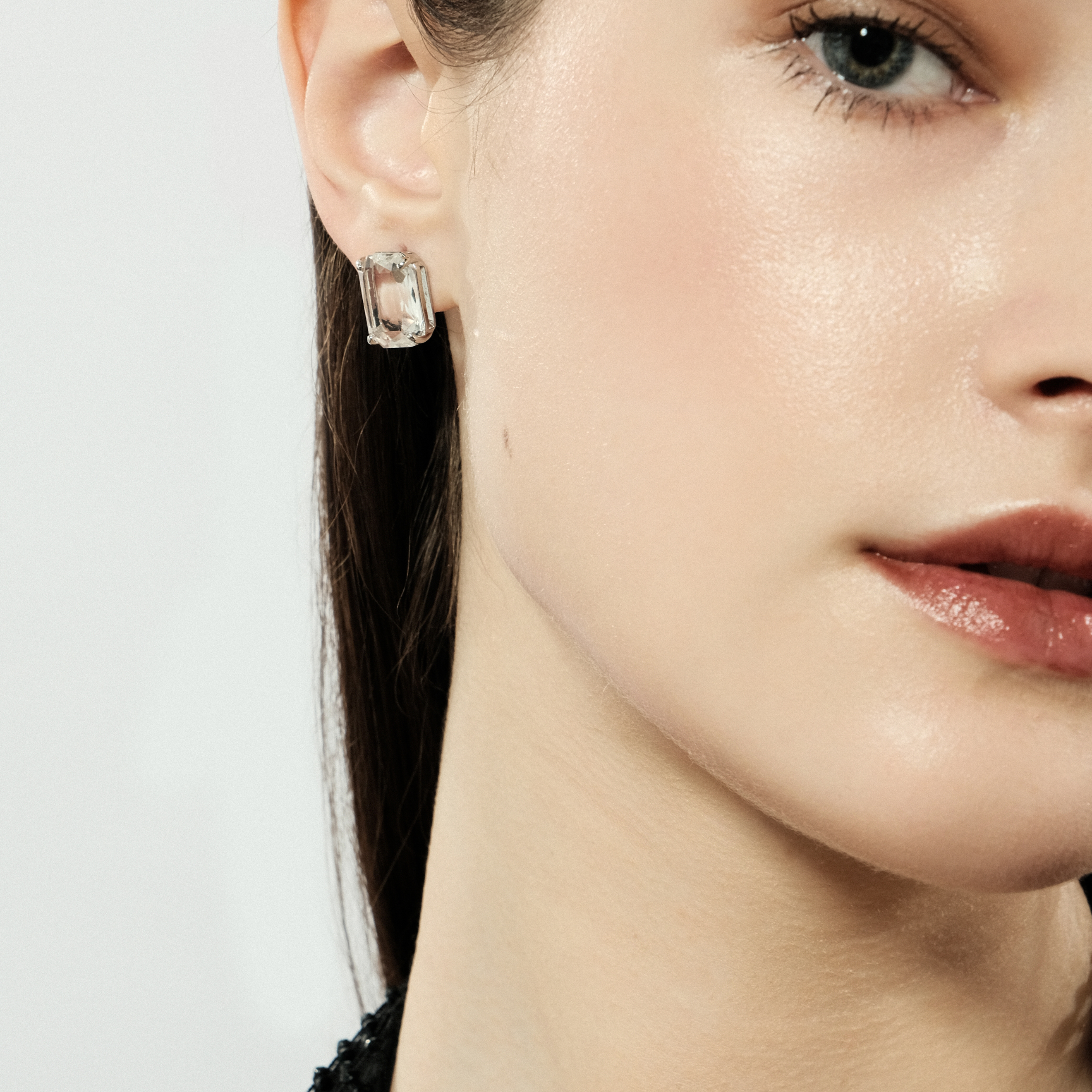 Silver stud earrings with a large white crystal