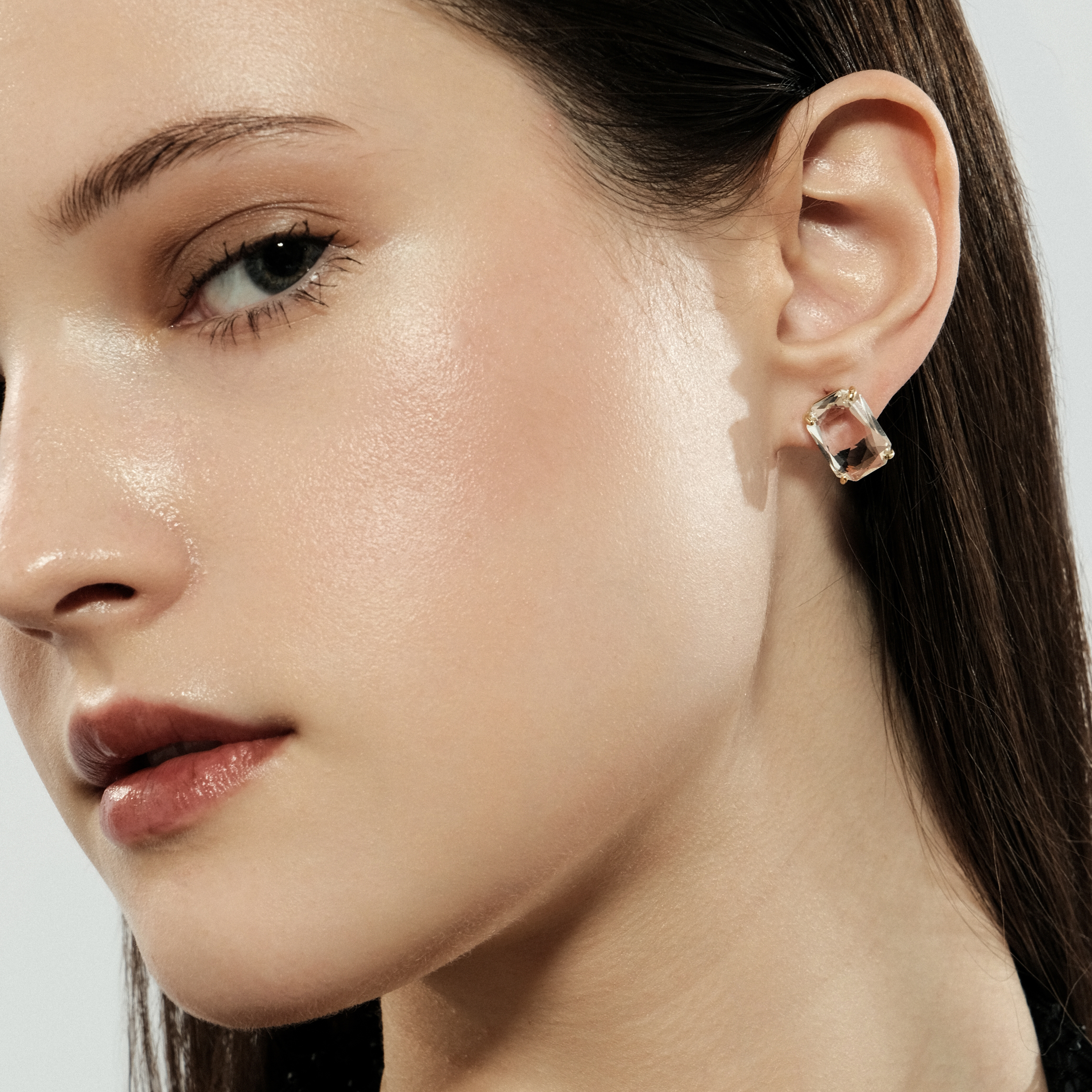 Golden stud earrings with a large white crystal