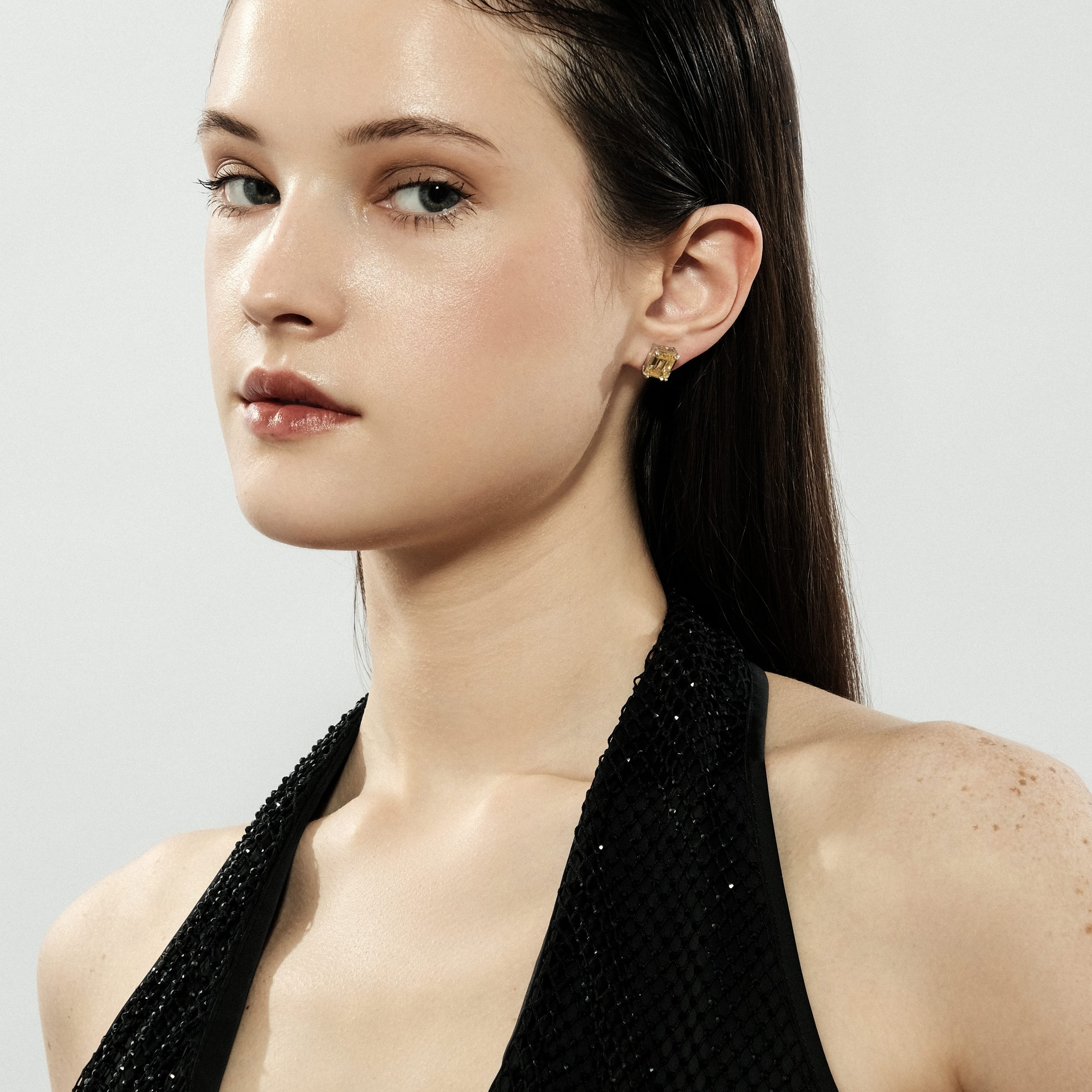 Silver stud earrings with a large yellow crystal