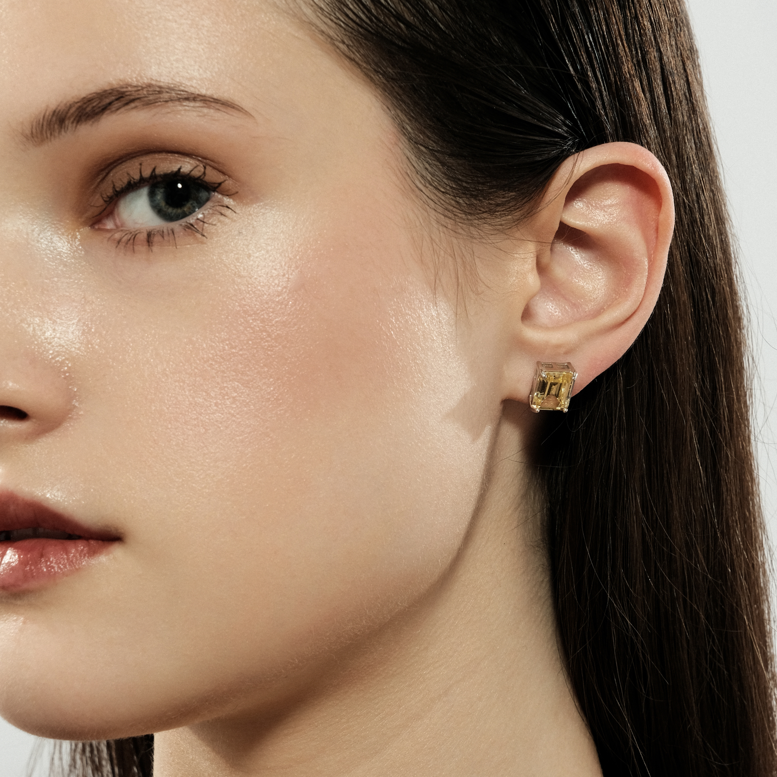 Silver stud earrings with a large yellow crystal