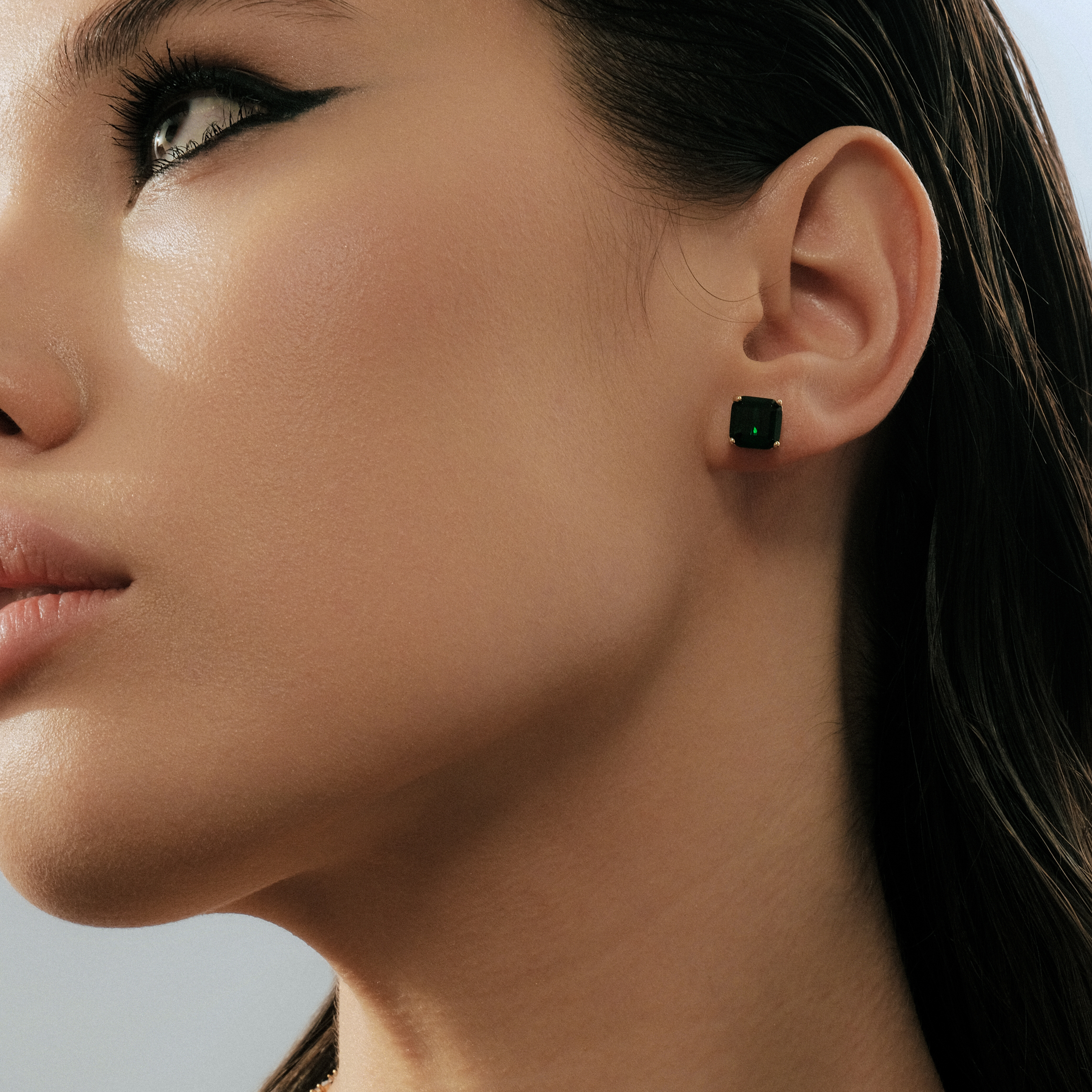 Golden earrings with green crystals