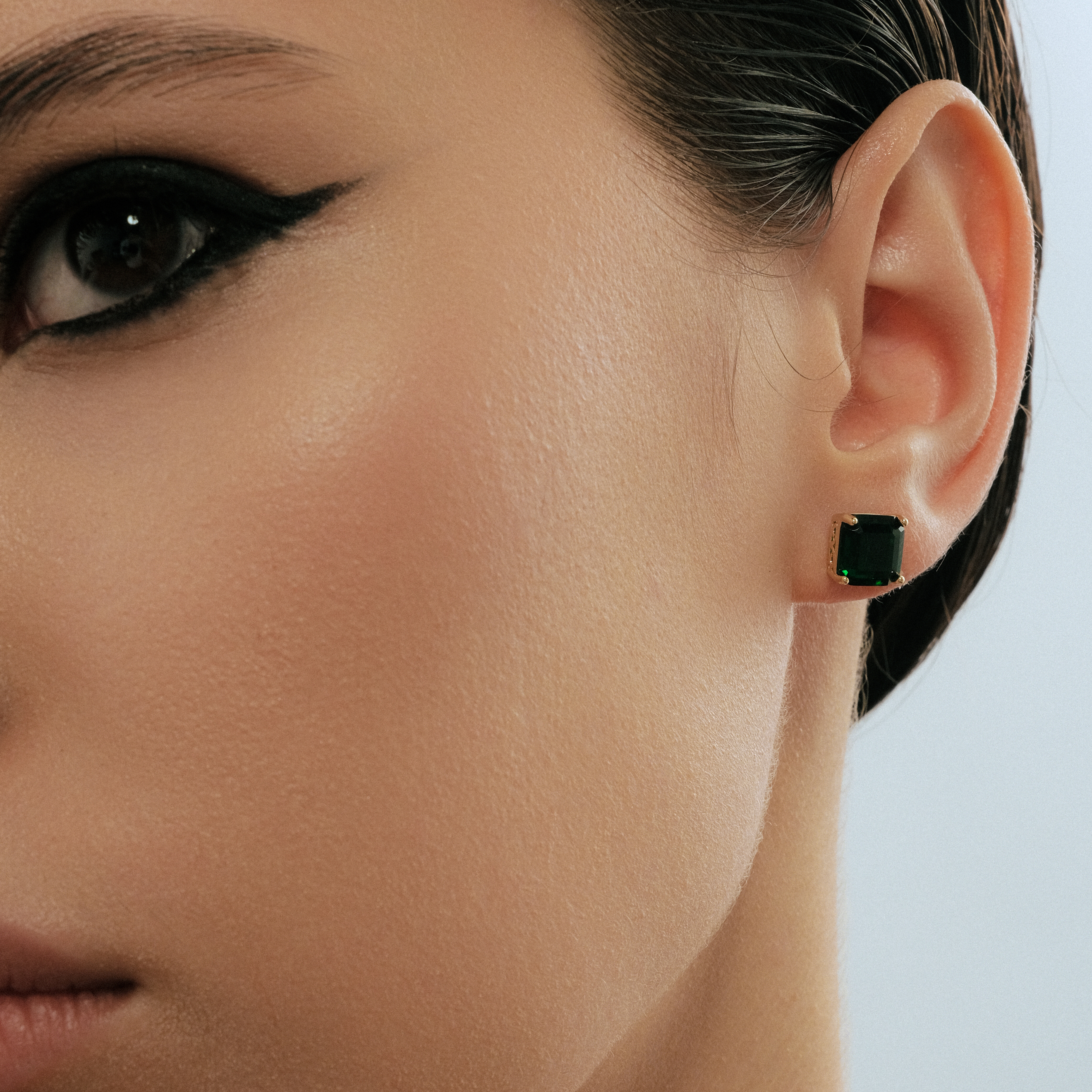 Golden earrings with green crystals