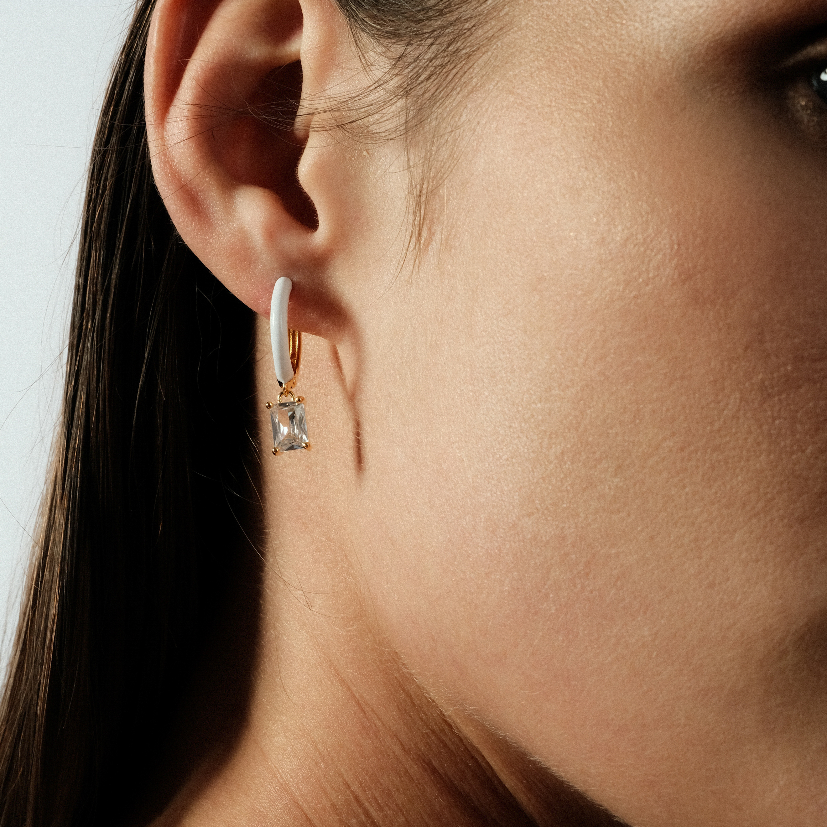 gold-tone enamel earrings with a baguette cut pendant