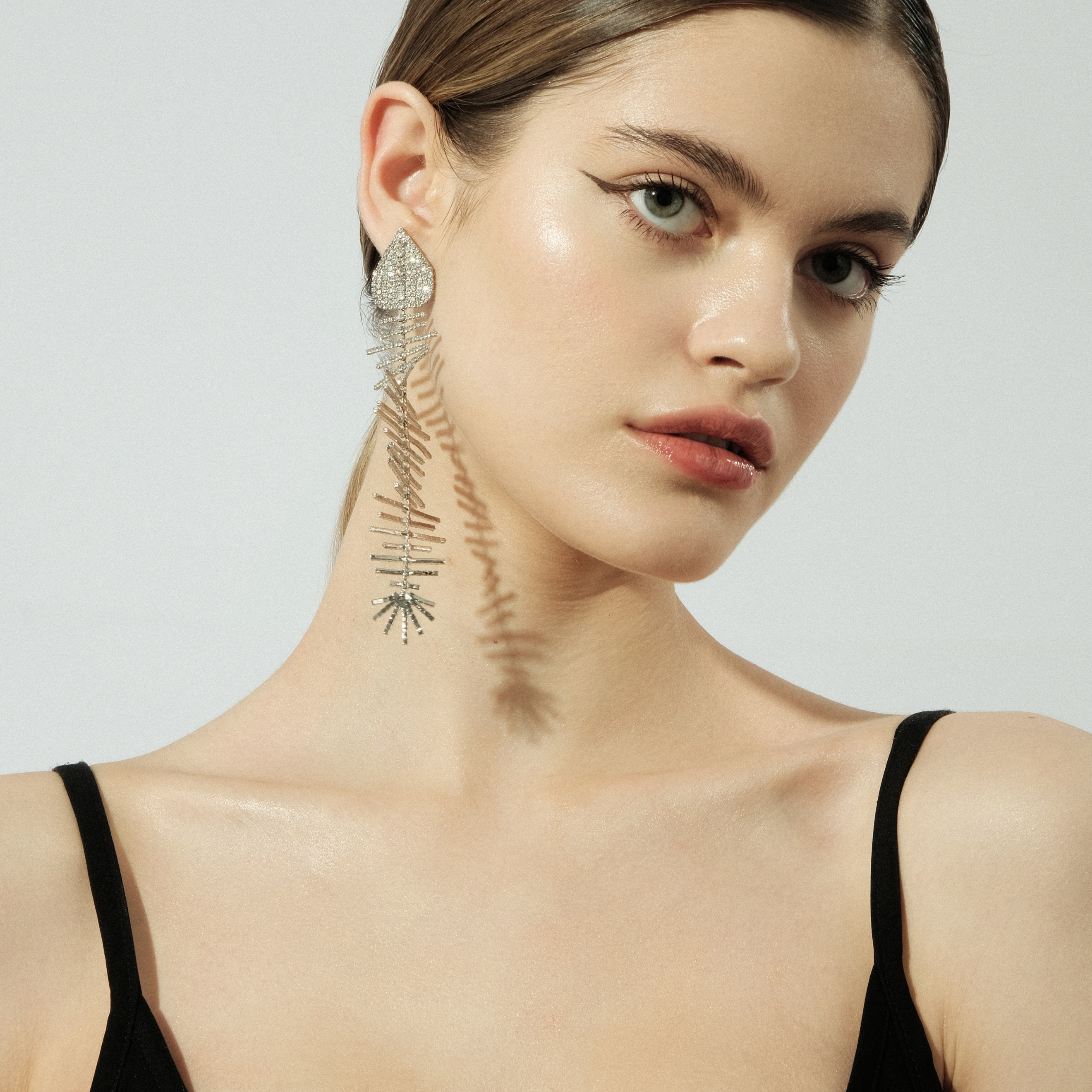 asymmetric earring set with a crystal fish and a pearl stud