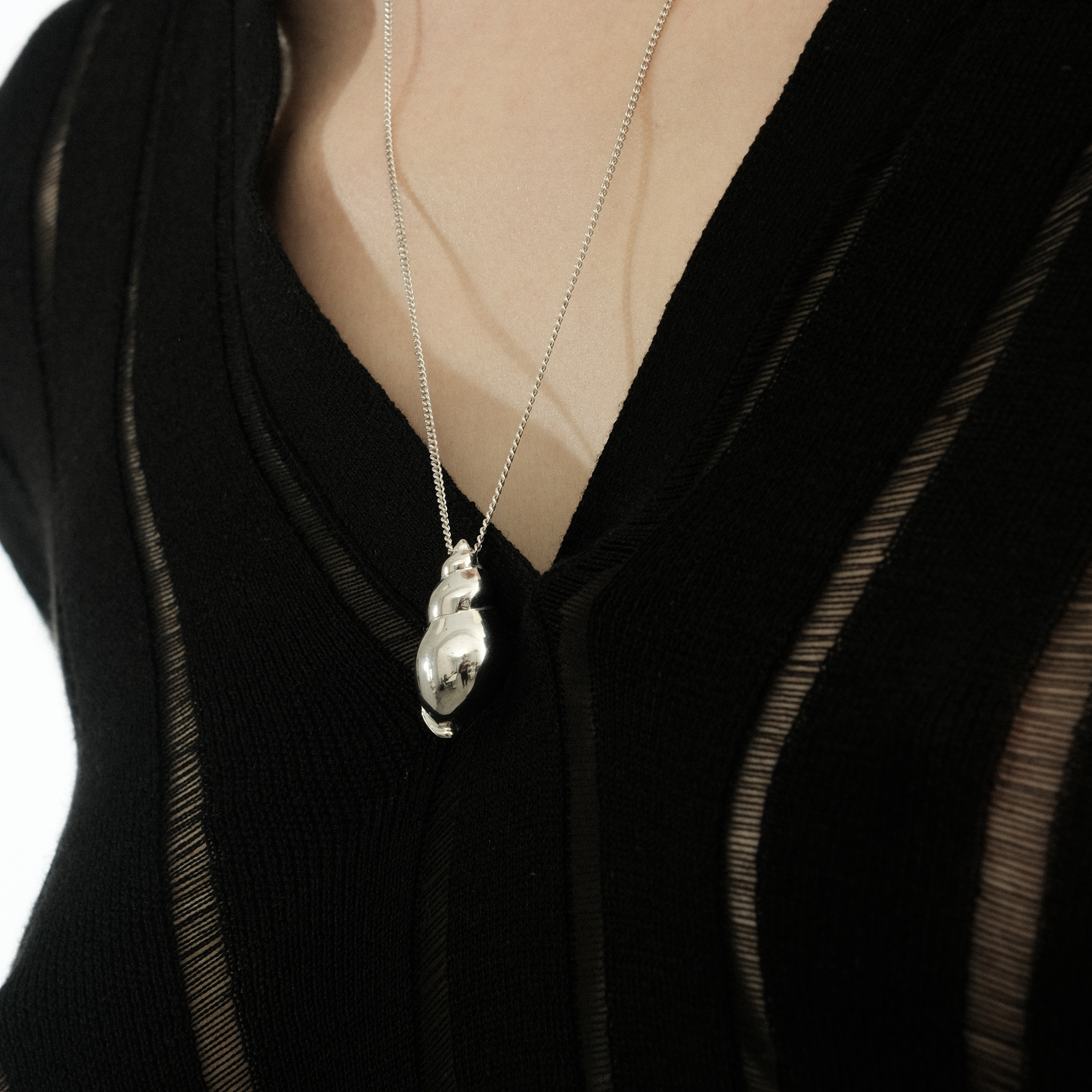 The Shell pendant is large made of white brass