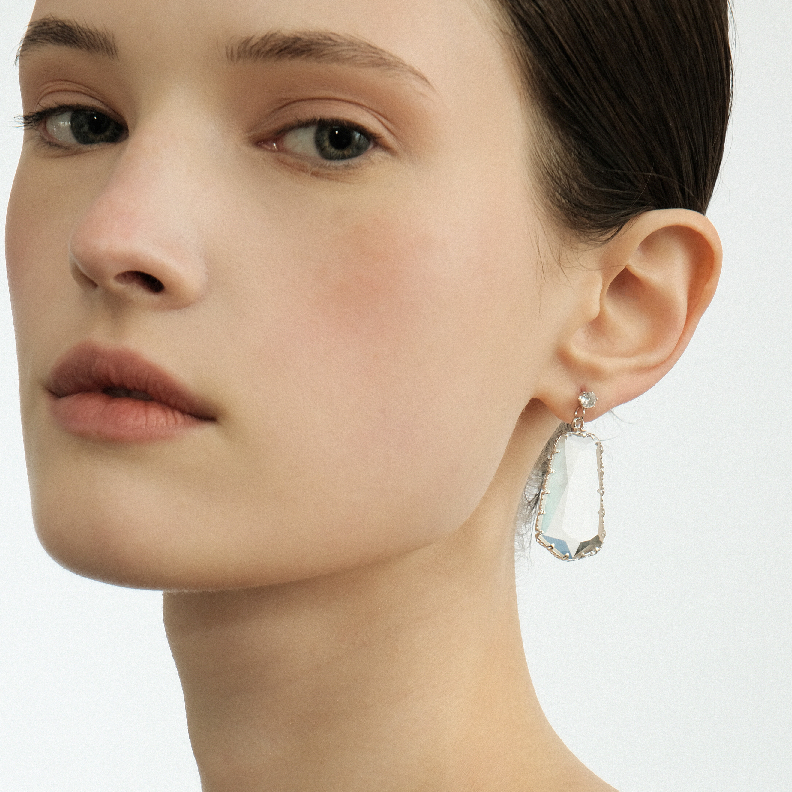 Earrings with a large transparent pentagonal crystal