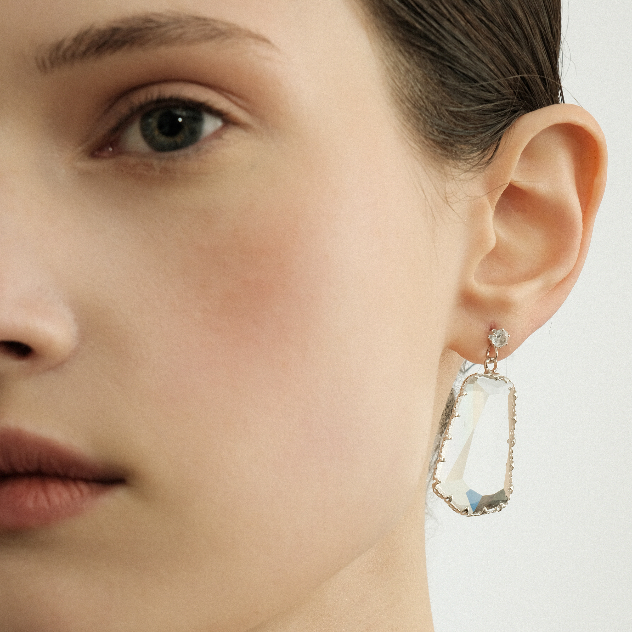Earrings with a large transparent pentagonal crystal