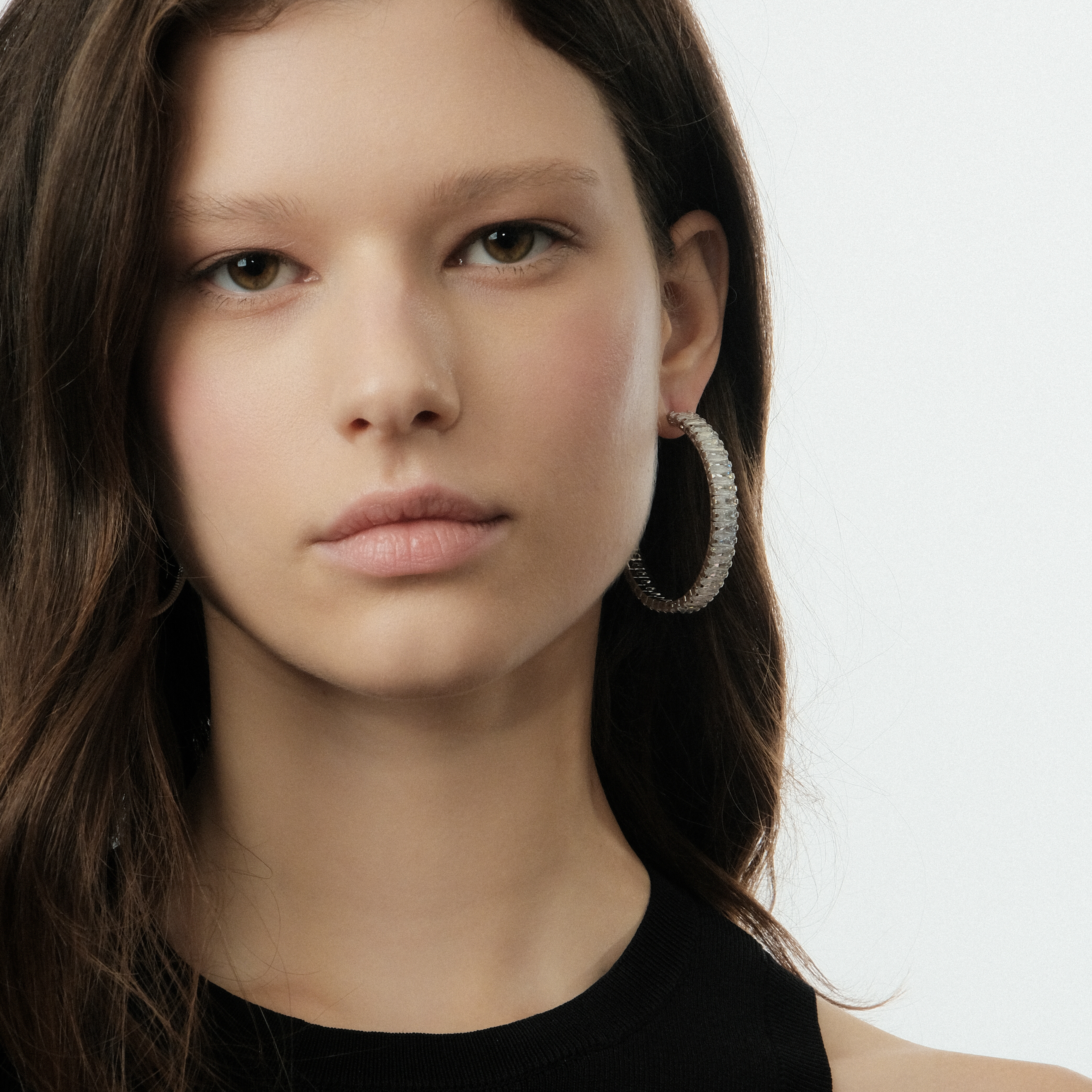 Silver hoop earrings with a track of white crystals