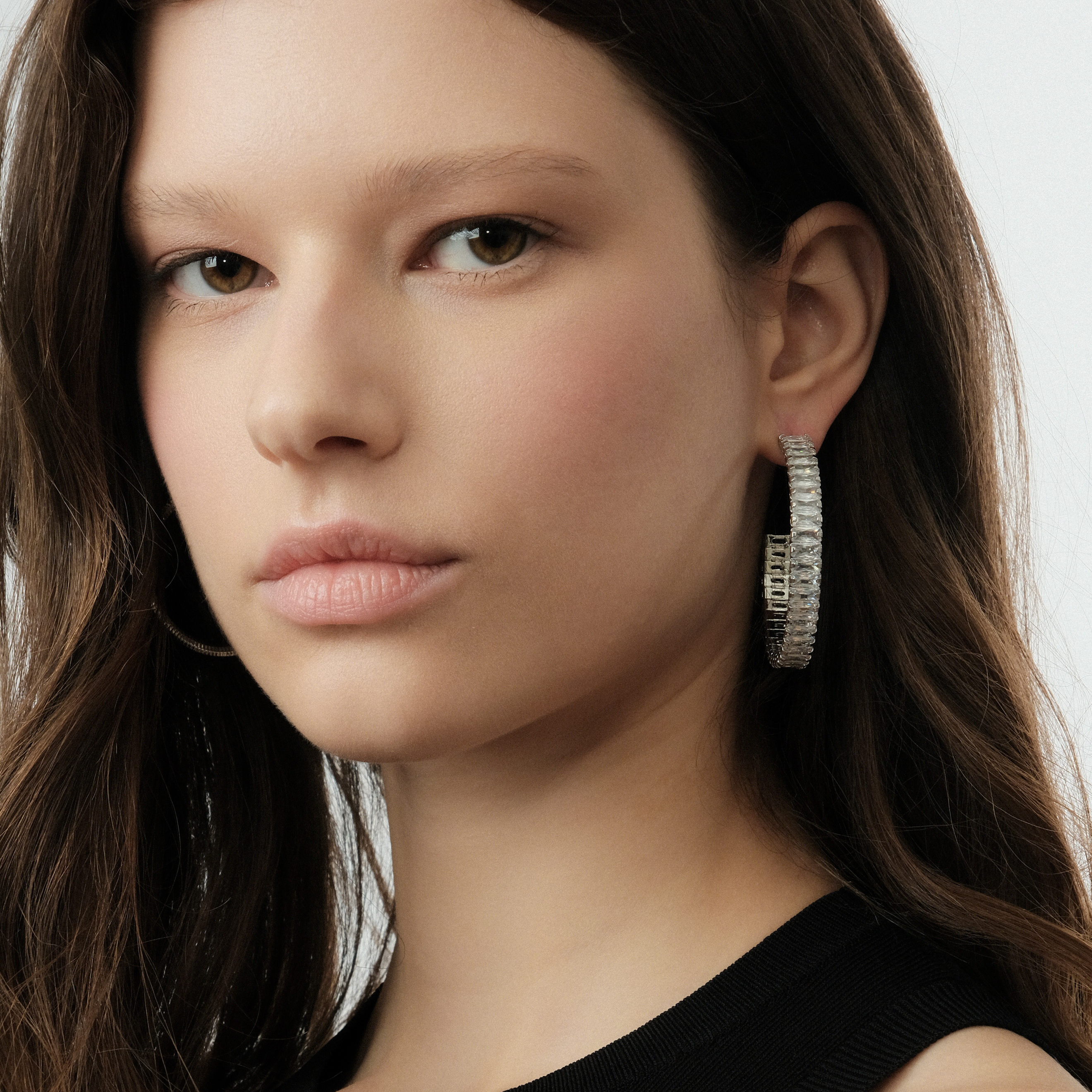Silver hoop earrings with a track of white crystals