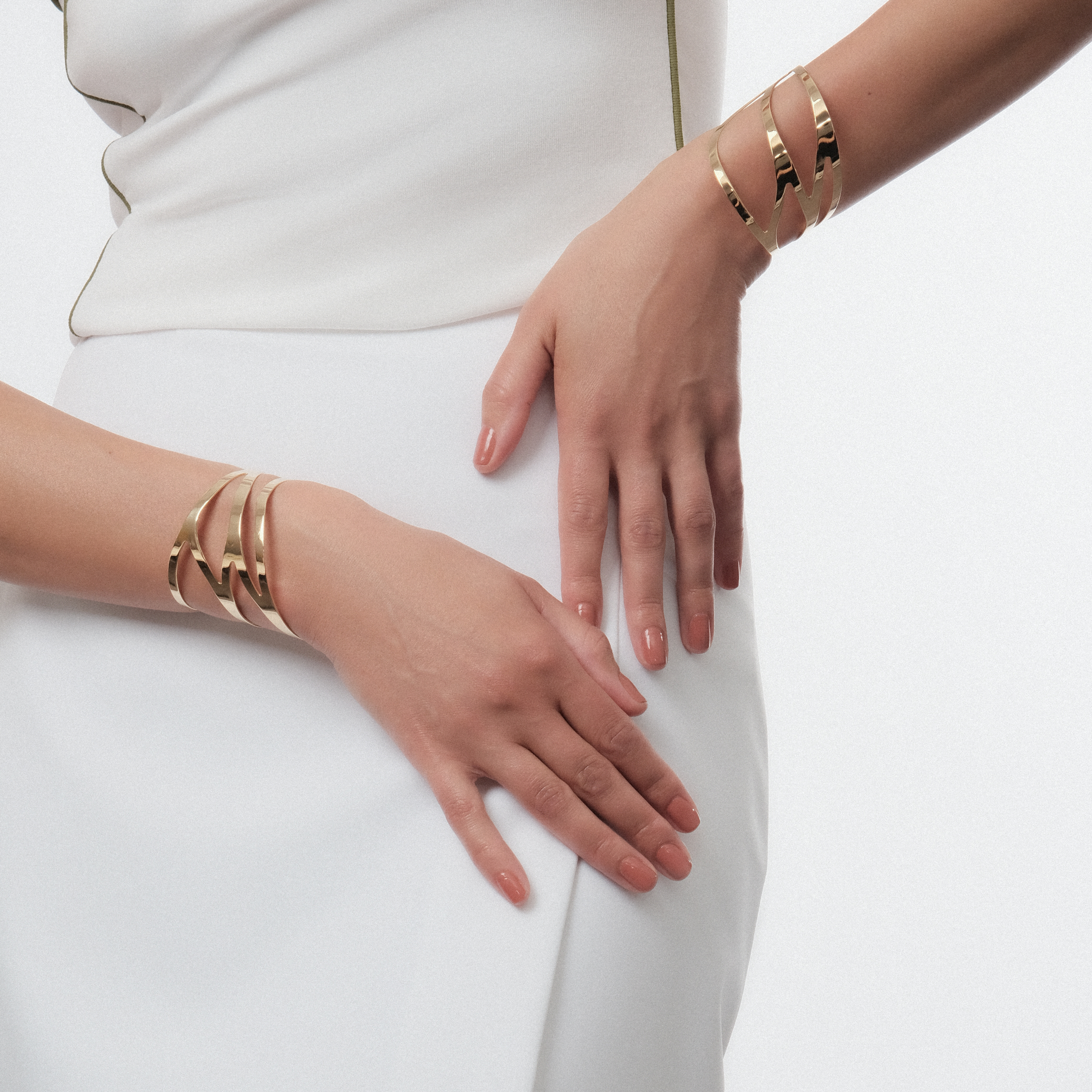 A pair of symmetrical adjustable gold-plated dragonfly bracelets on the wrist