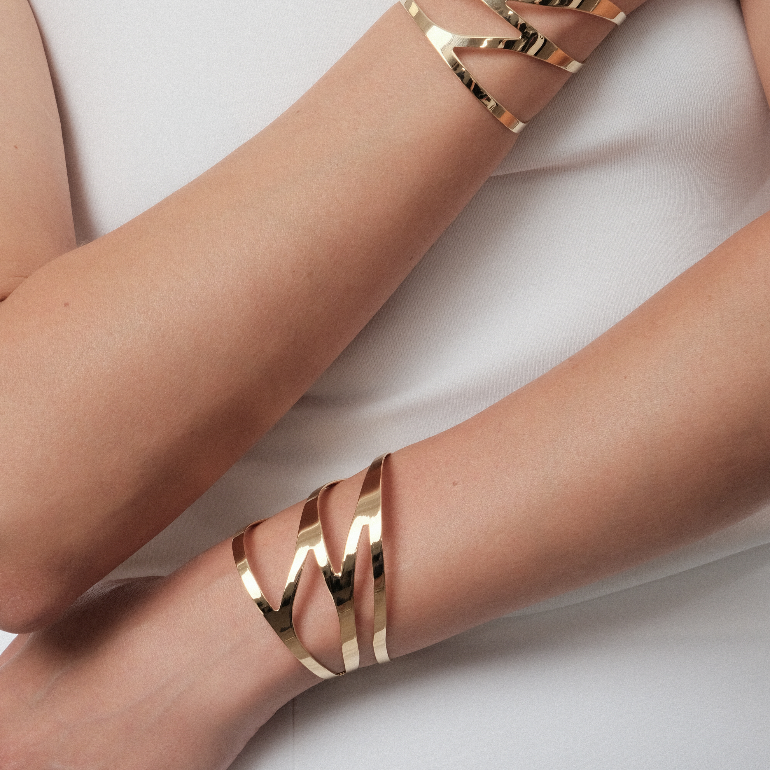 A pair of symmetrical adjustable gold-plated dragonfly bracelets on the wrist