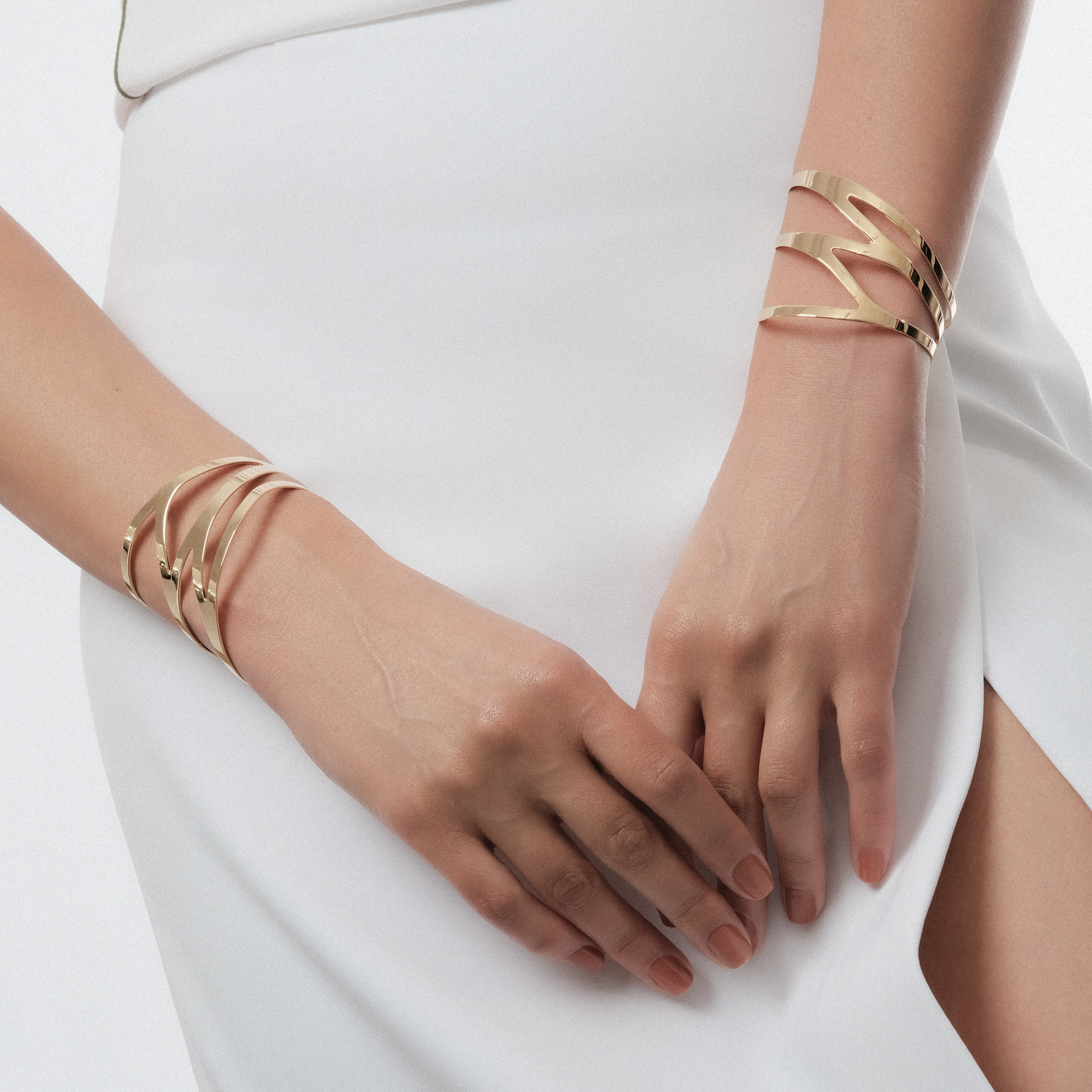 A pair of symmetrical adjustable gold-plated dragonfly bracelets on the wrist