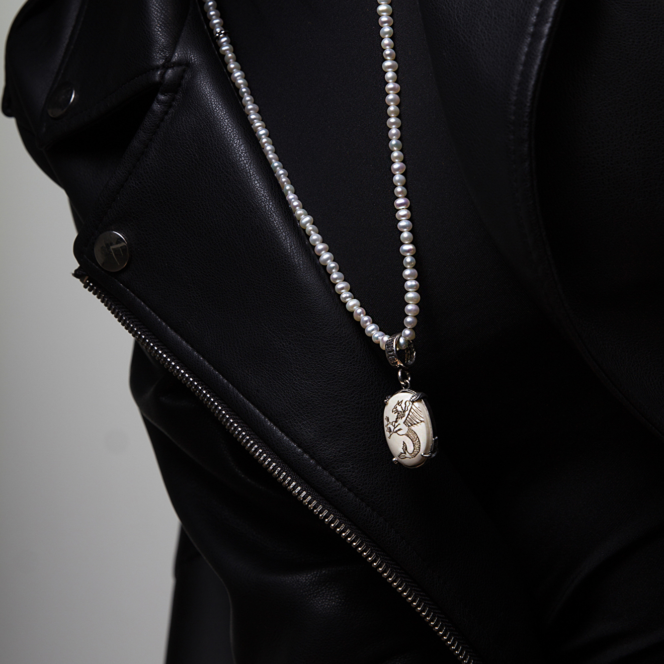 Silver pendant with bone and wyvern pattern