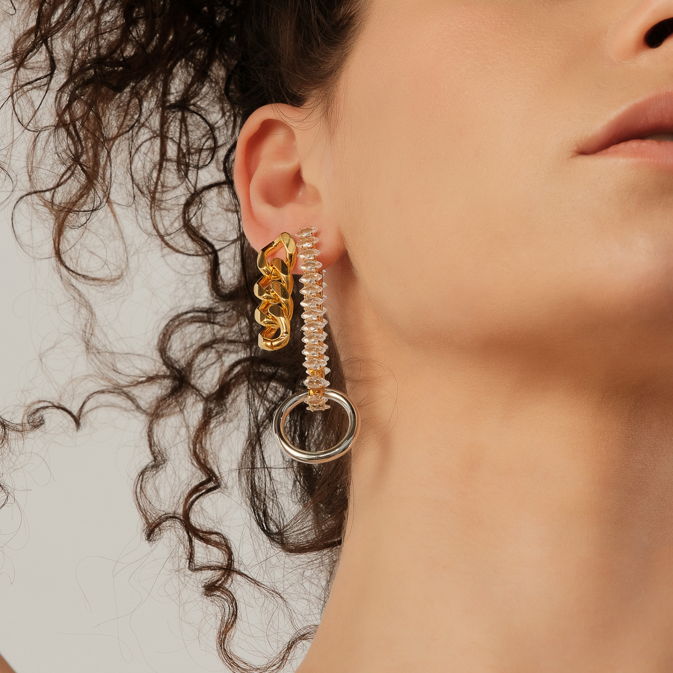 asymmetric earrings with a silver circle and crystals