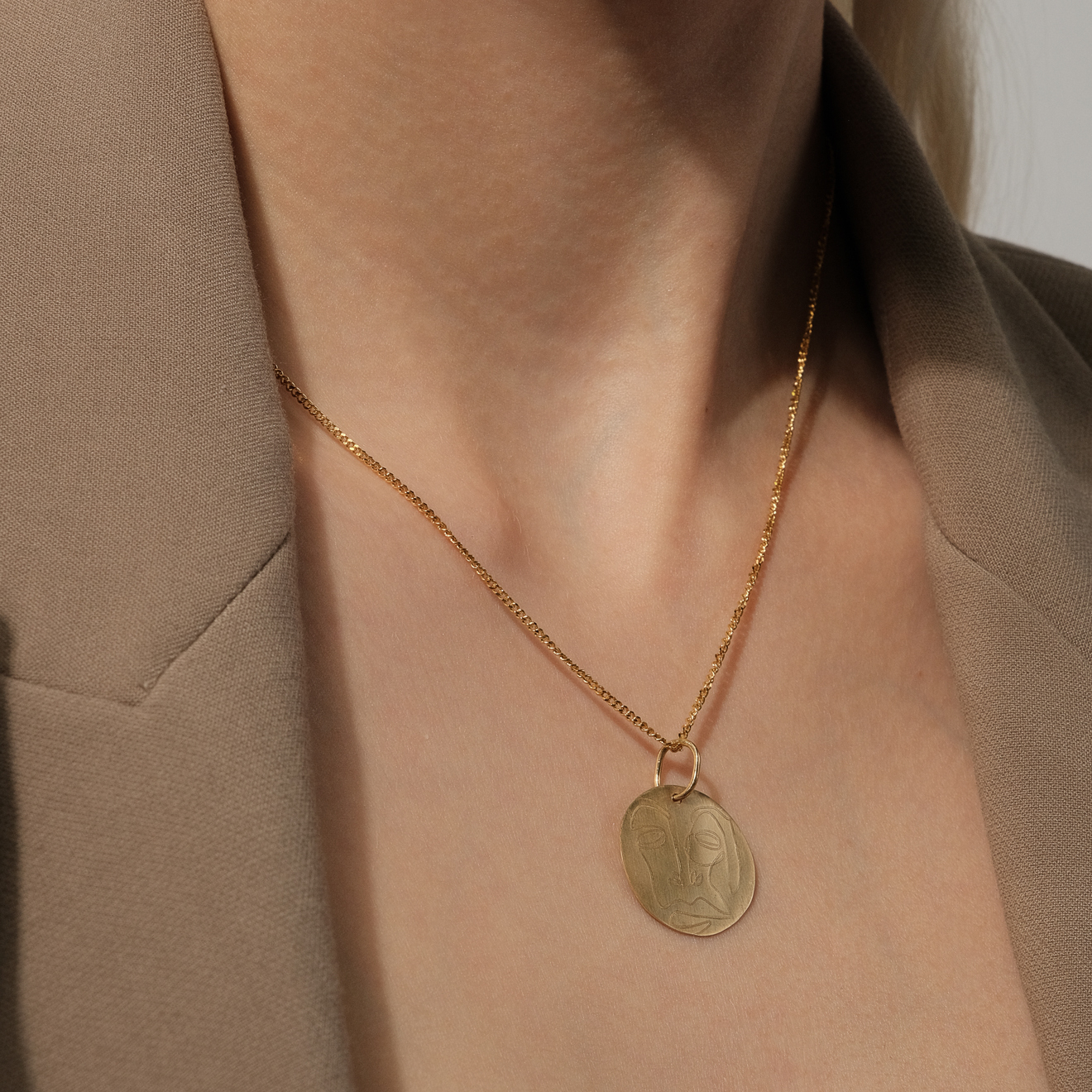 Gold-plated necklace with a pendant with a face