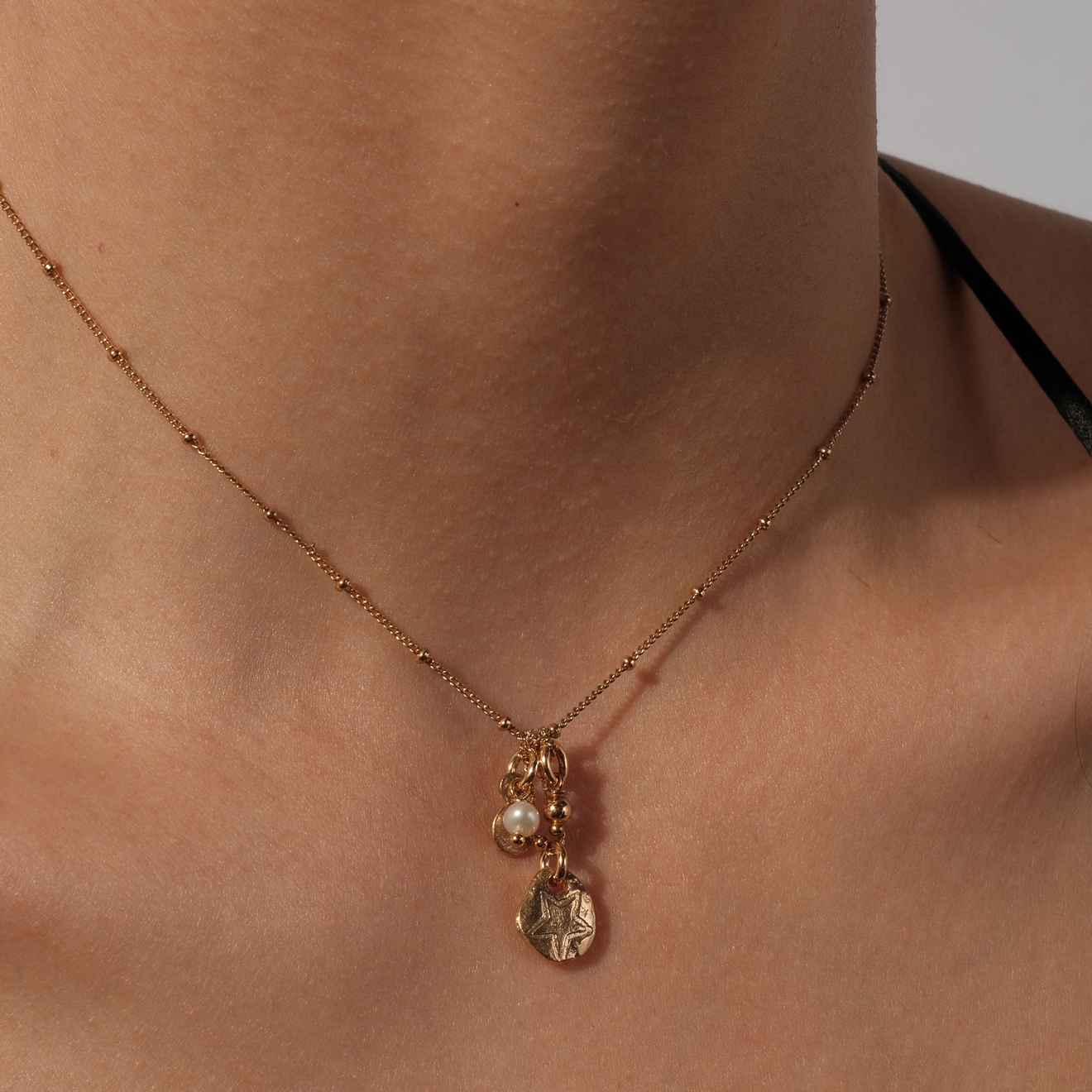 Gold-plated necklace with textured pendant medallions and pearls