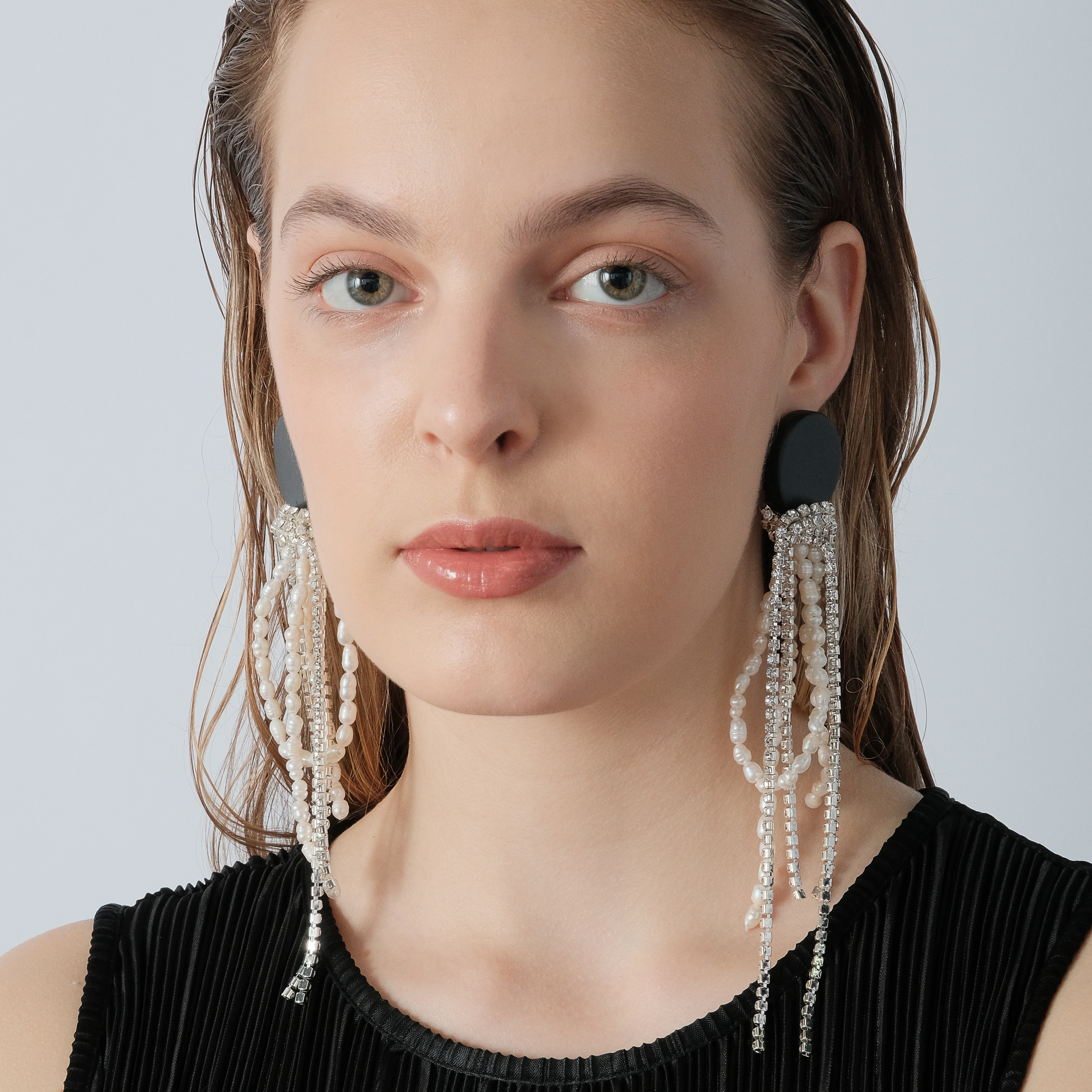 Black circle earrings made of wood with cascading pendants made of colored crystals and pearls