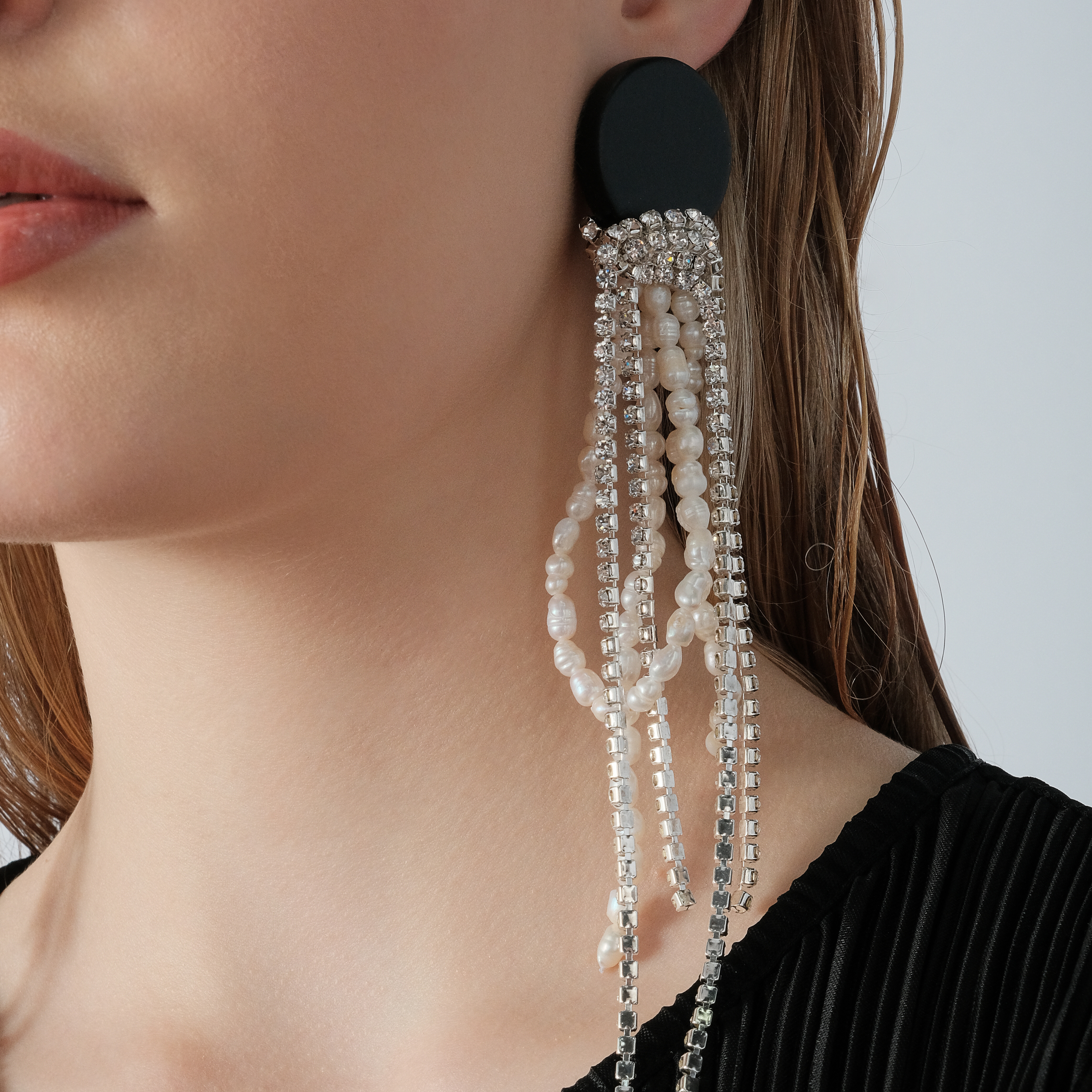 Black circle earrings made of wood with cascading pendants made of colored crystals and pearls