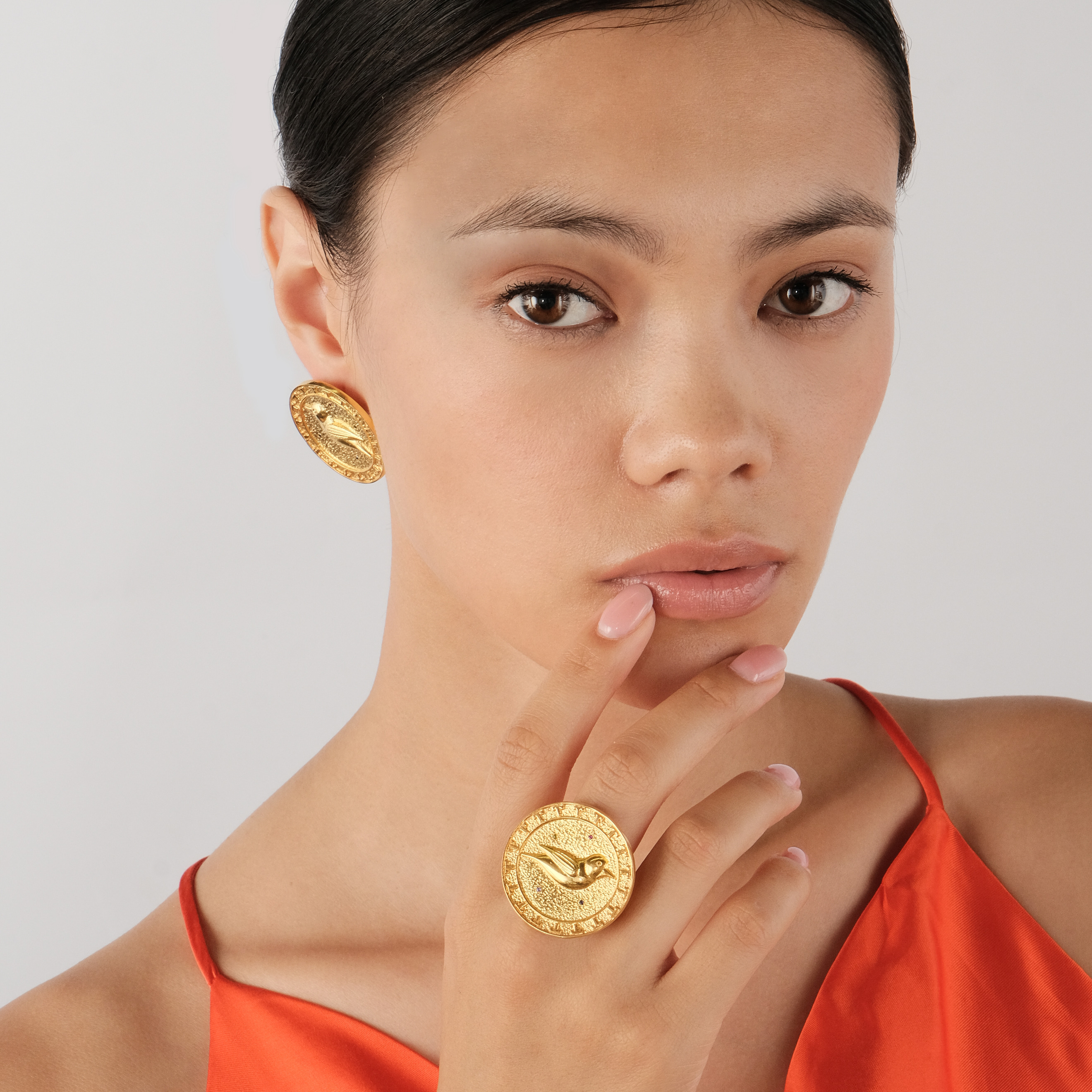 Gold-plated round ring with a bird and white and red crystals