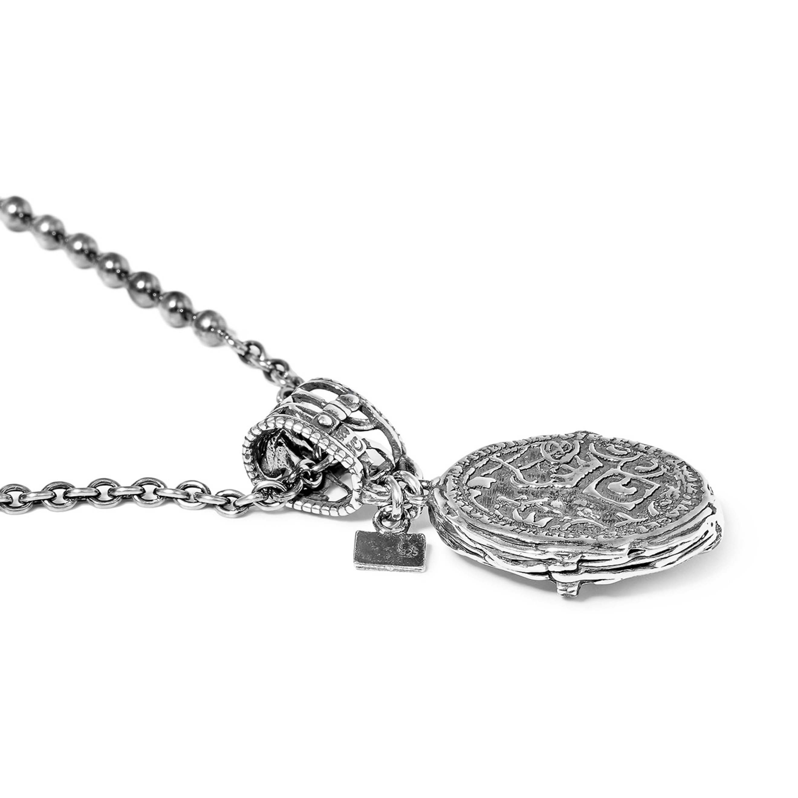 Silver medallion with the letter T