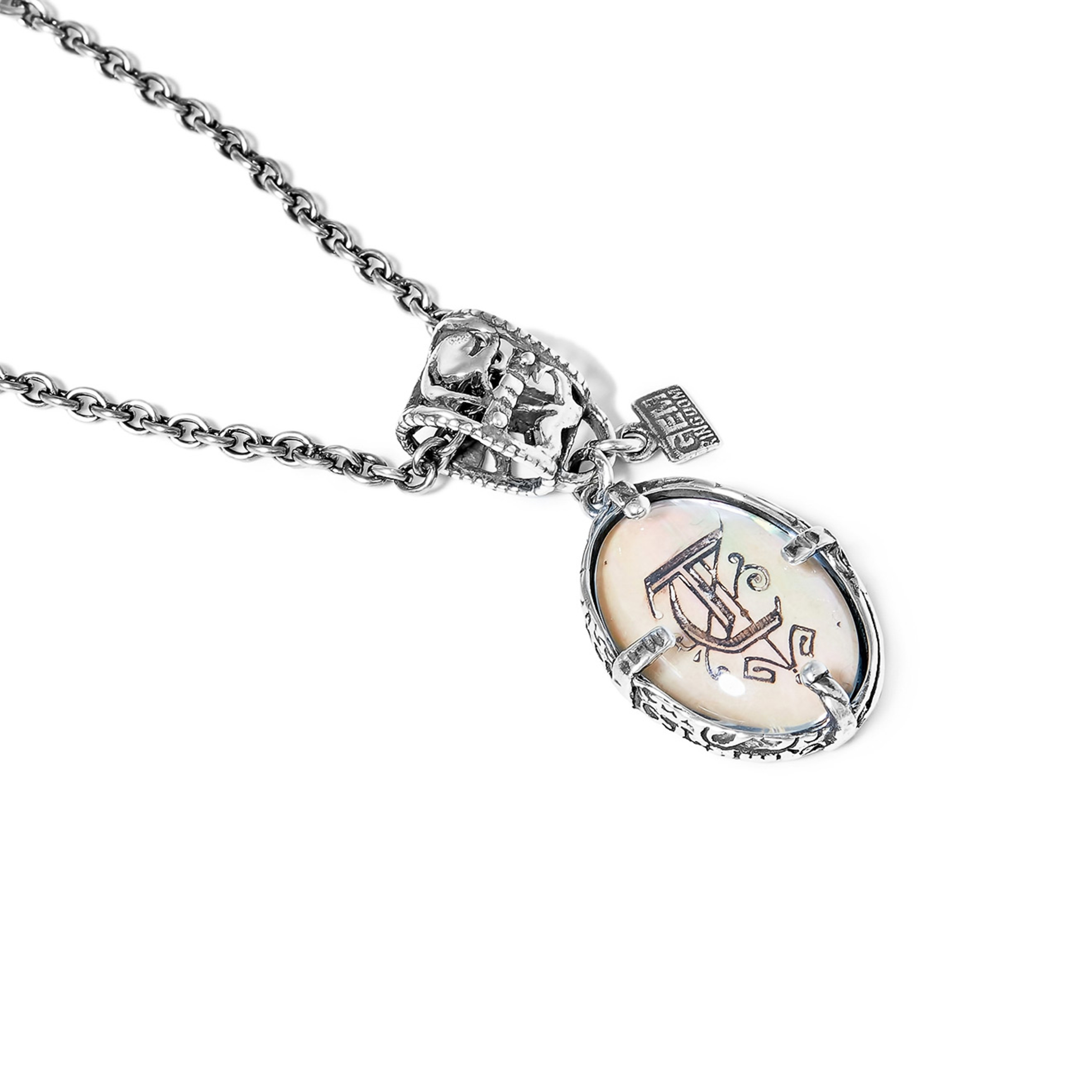 Silver medallion with the letter T