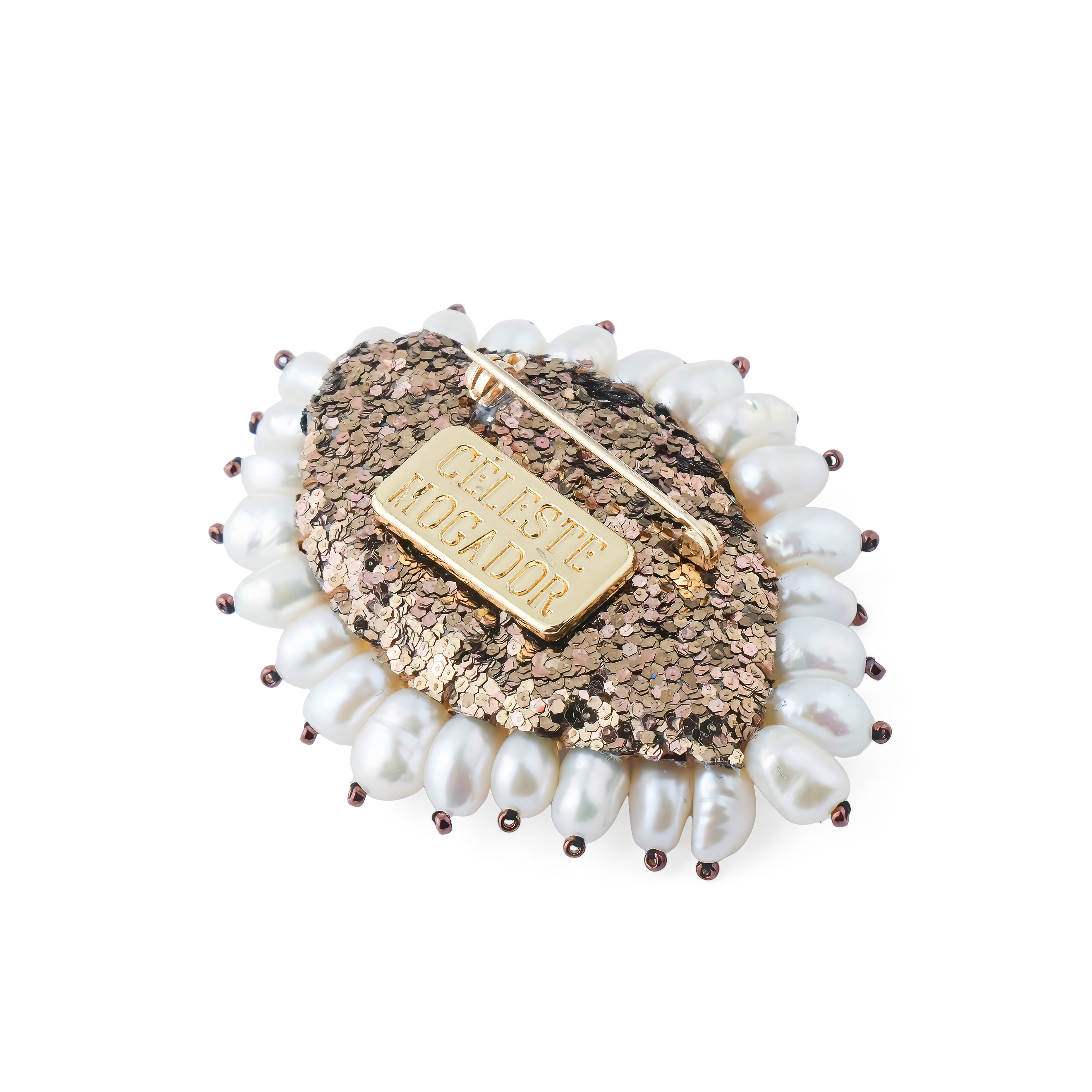 The brooch in the form of an eye is small with white pearls and a brown eye