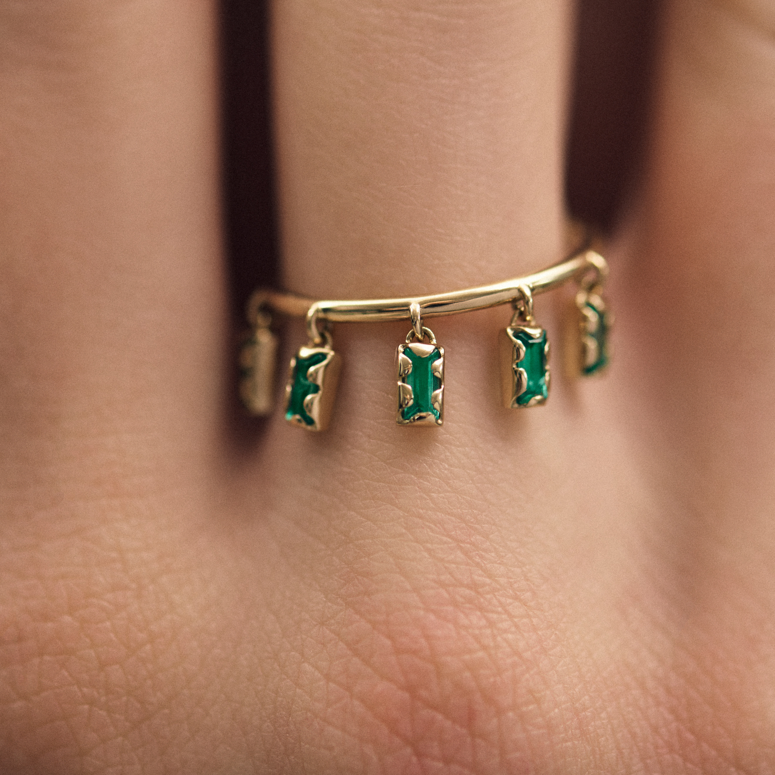 Ring with 5 hanging emeralds in an asymmetric fastening