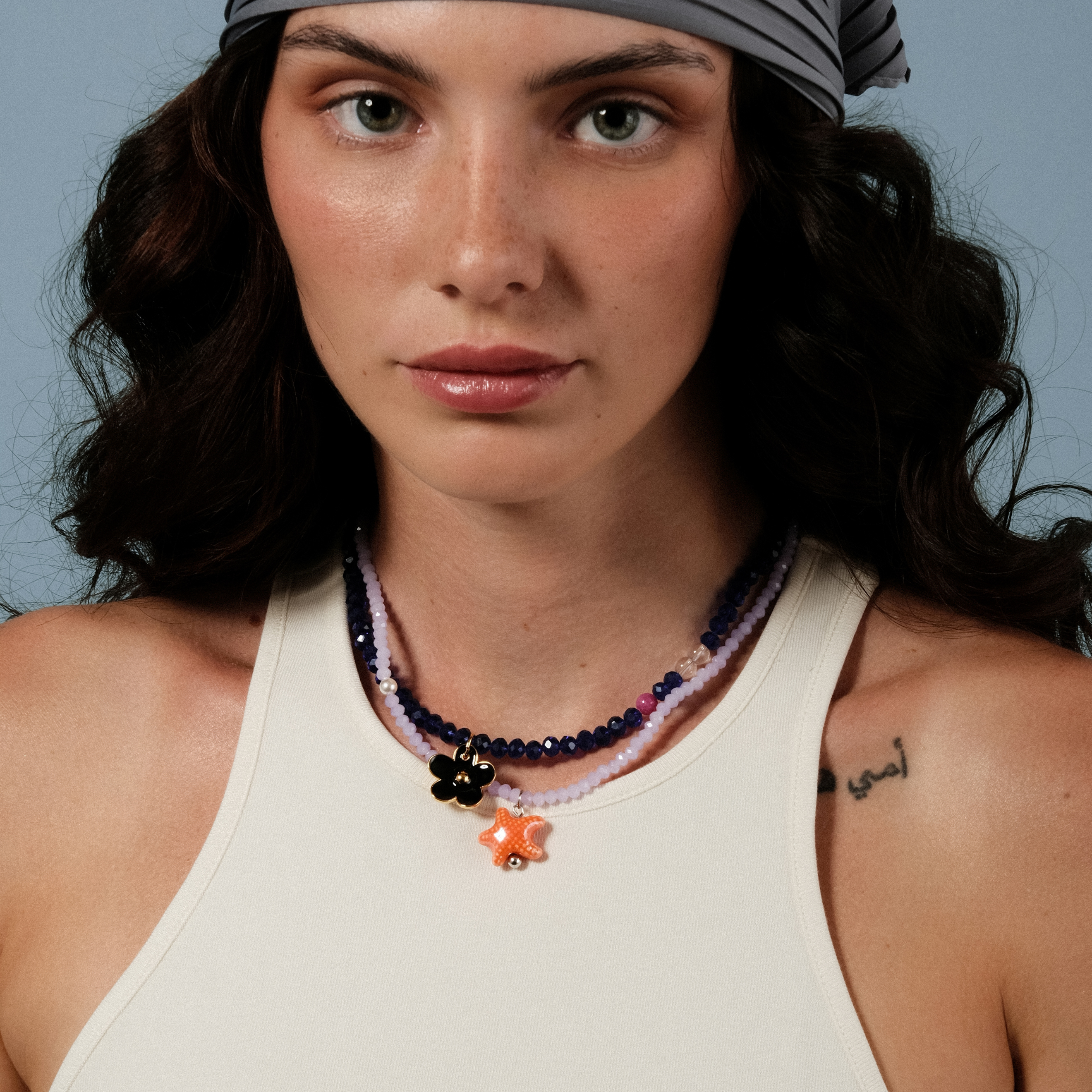 blue bead necklace with a black flower