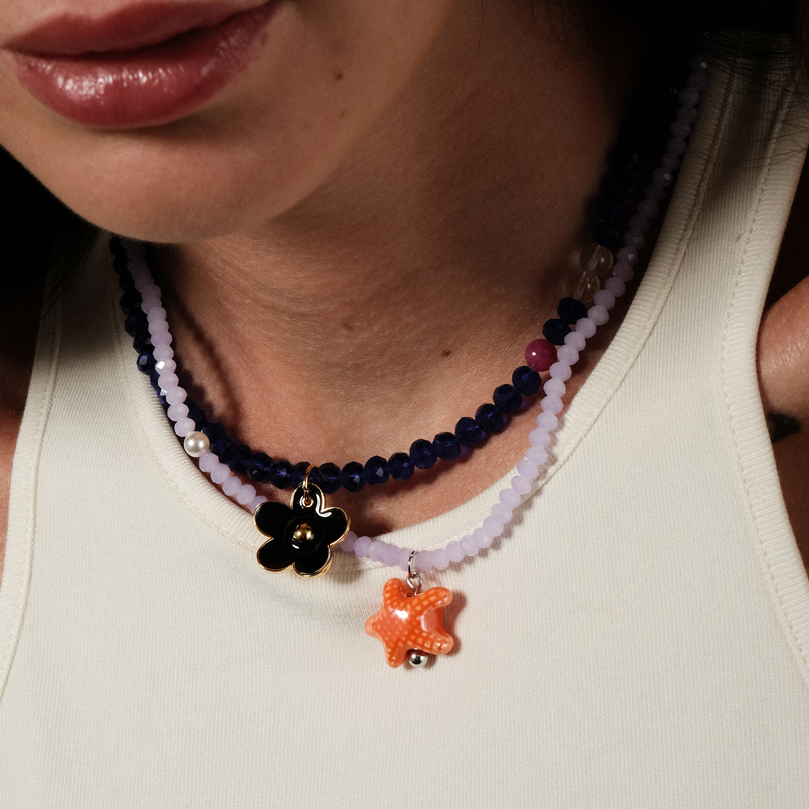 blue bead necklace with a black flower