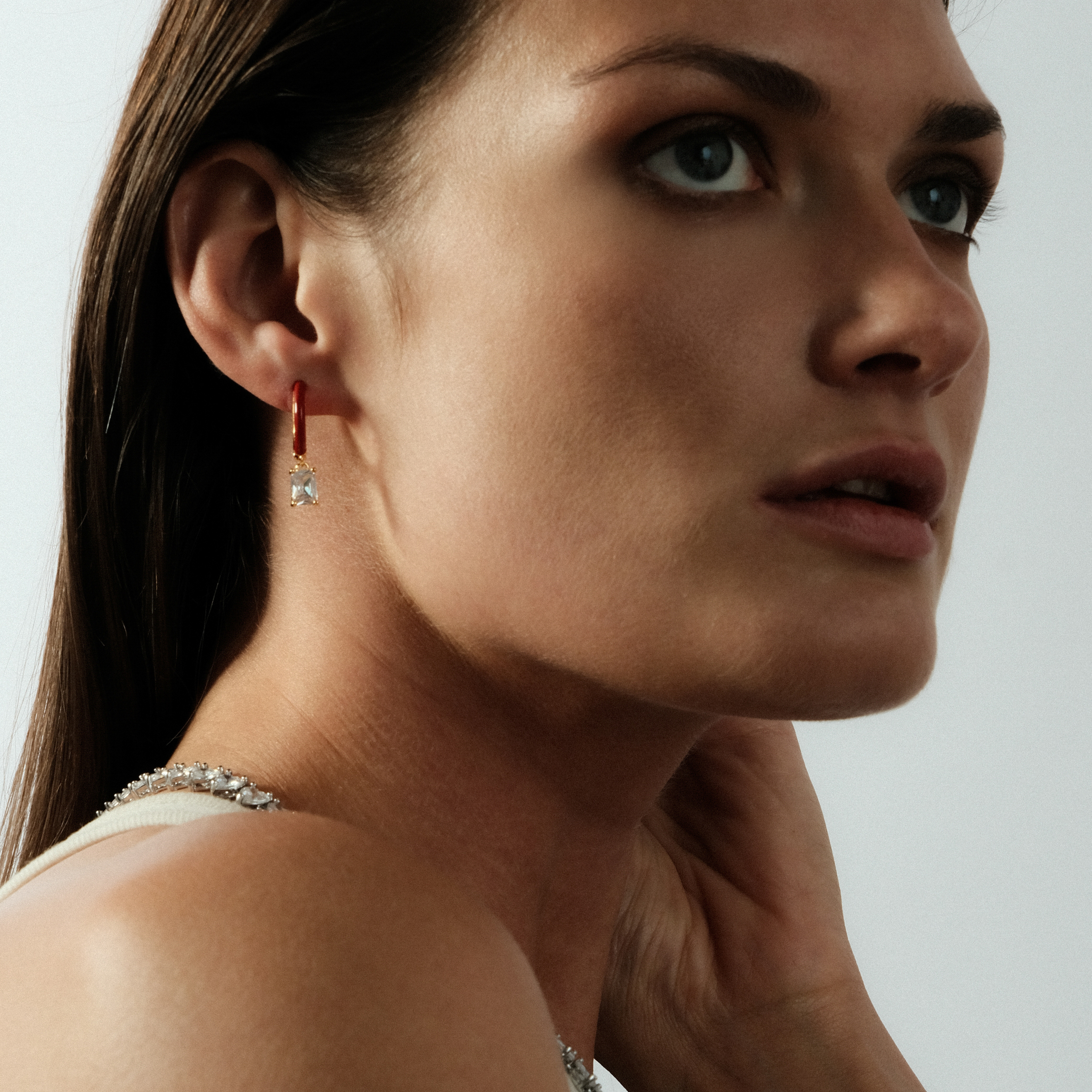 gold-tone enamel earrings with a baguette cut pendant
