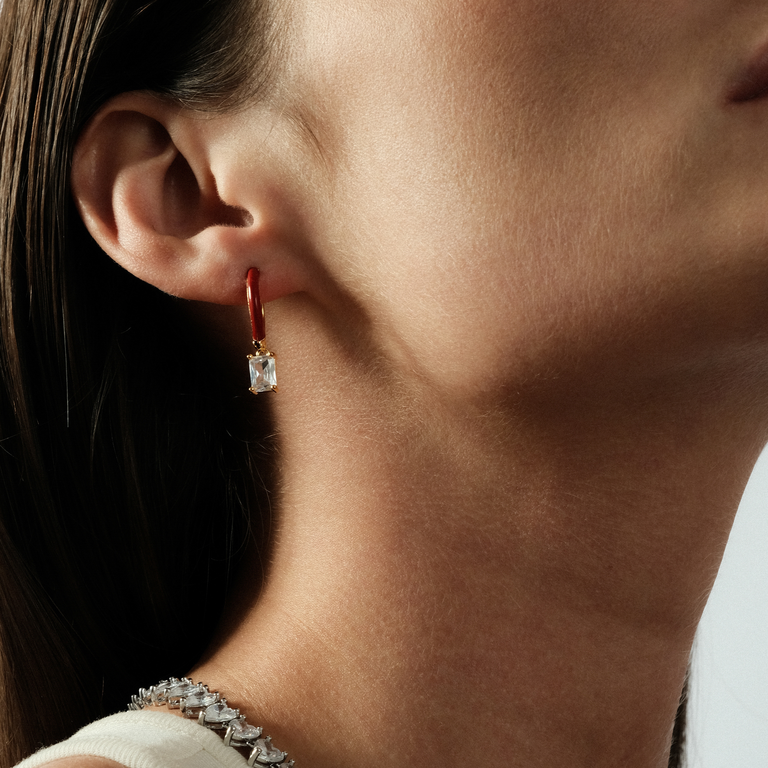 gold-tone enamel earrings with a baguette cut pendant