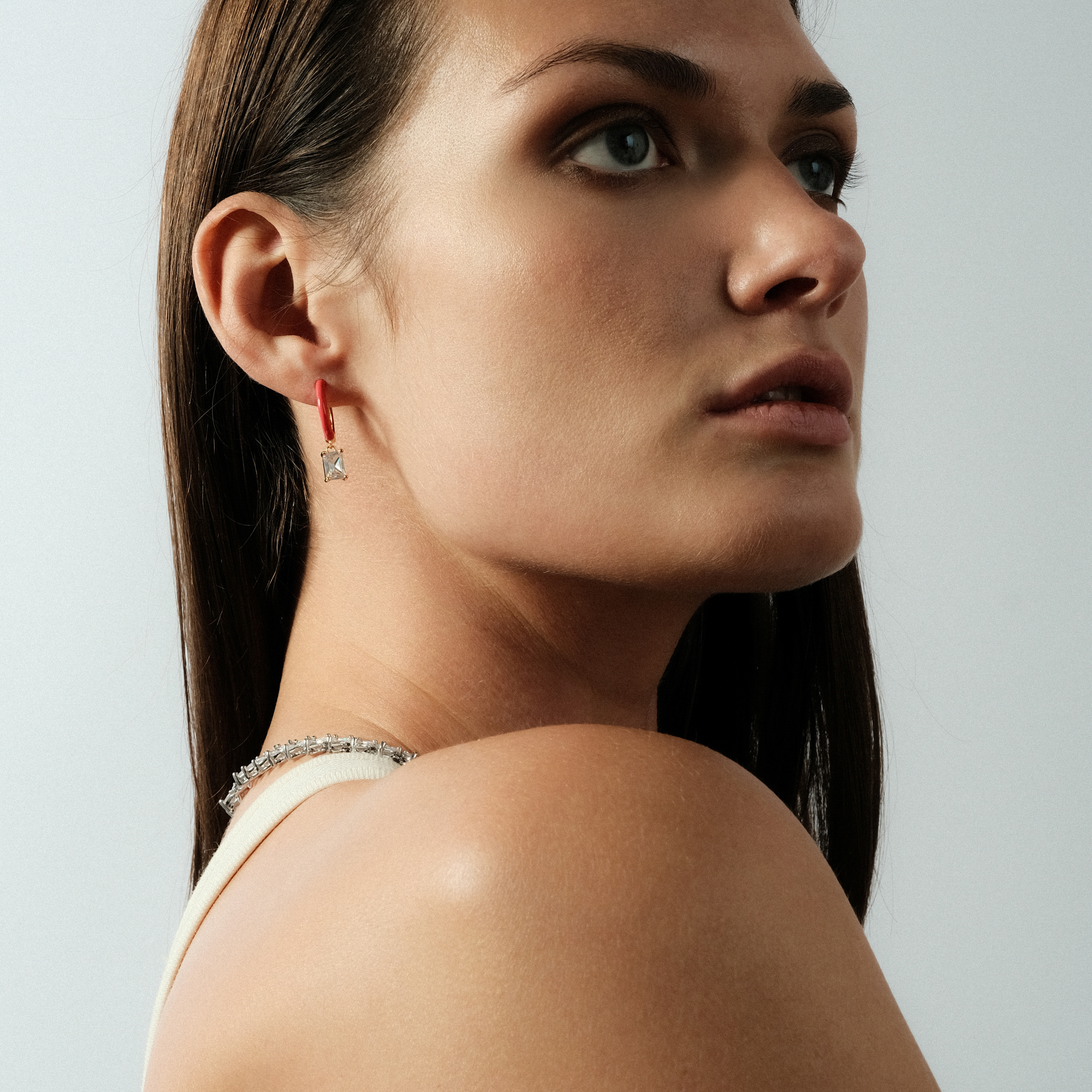gold-tone enamel earrings with a baguette cut pendant