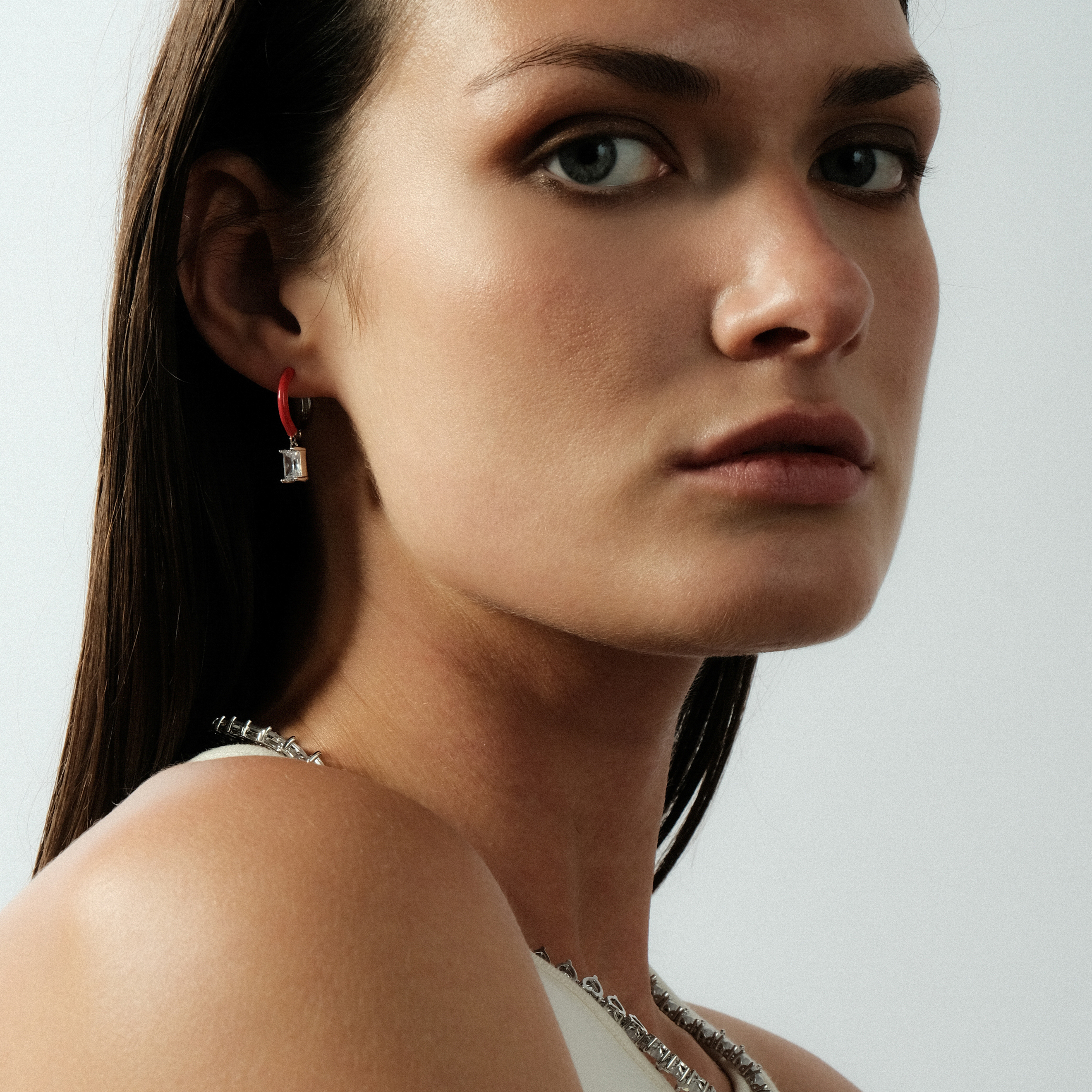 earrings with red enamel with a baguette cut pendant