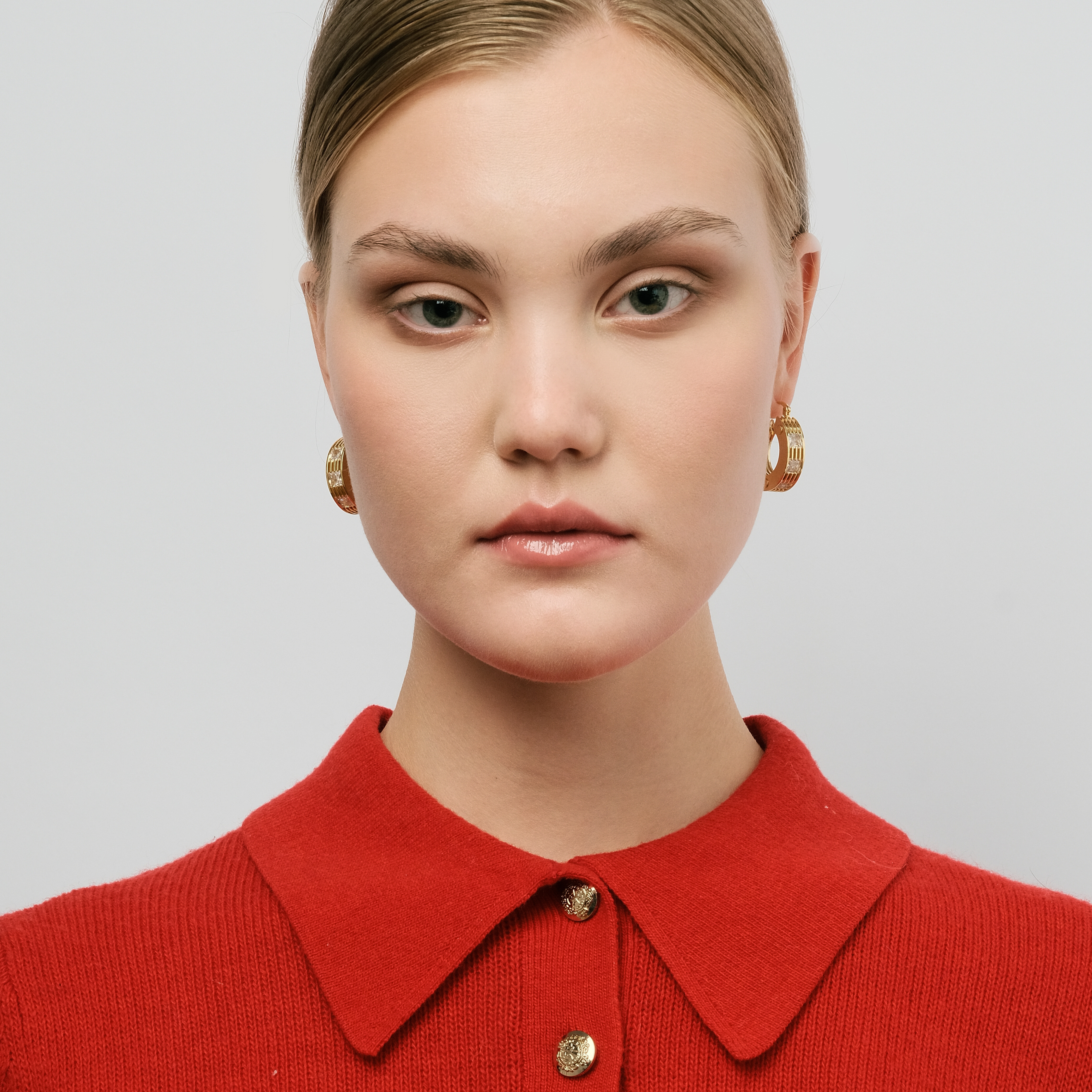 Golden round earrings made of several plates with crystals