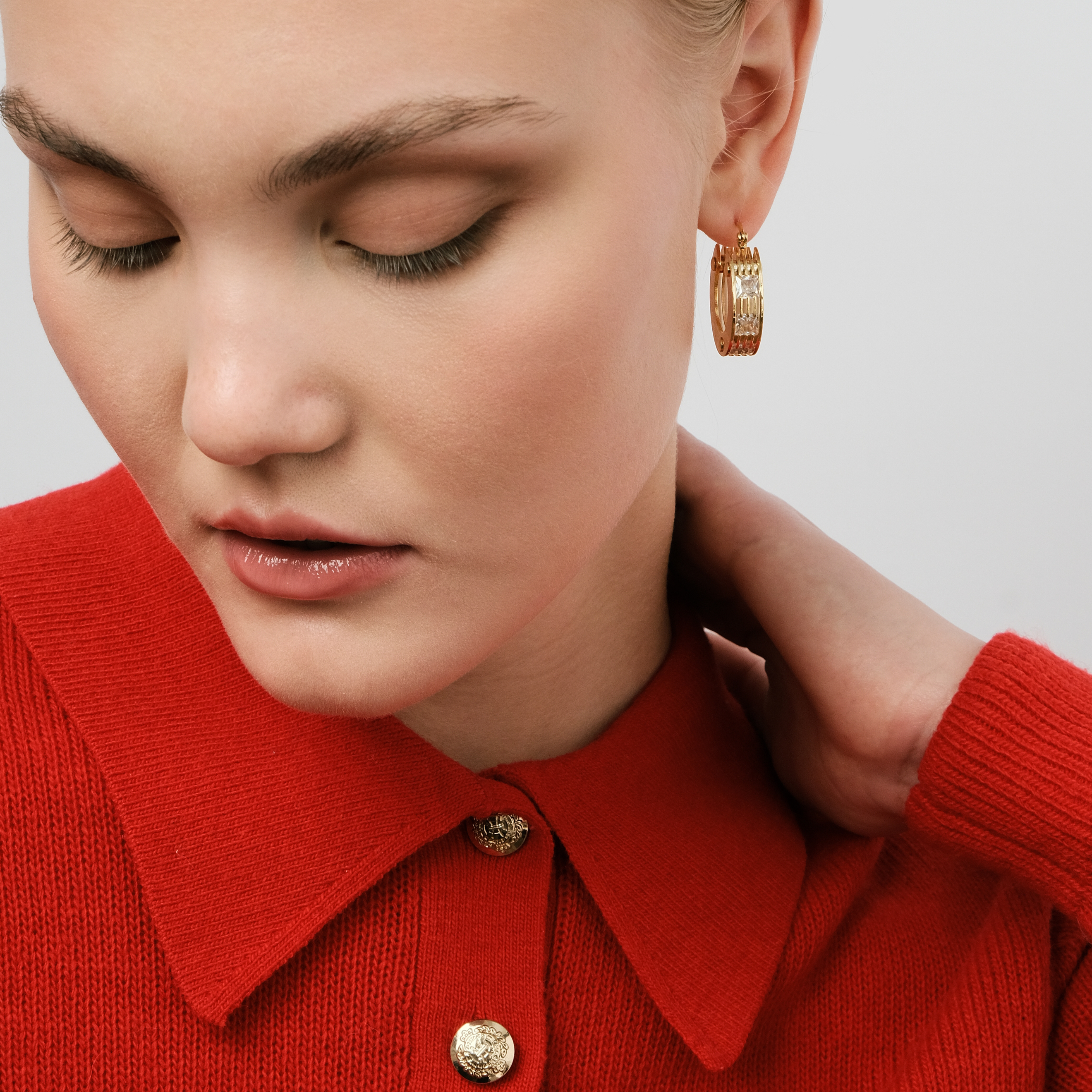 Golden round earrings made of several plates with crystals