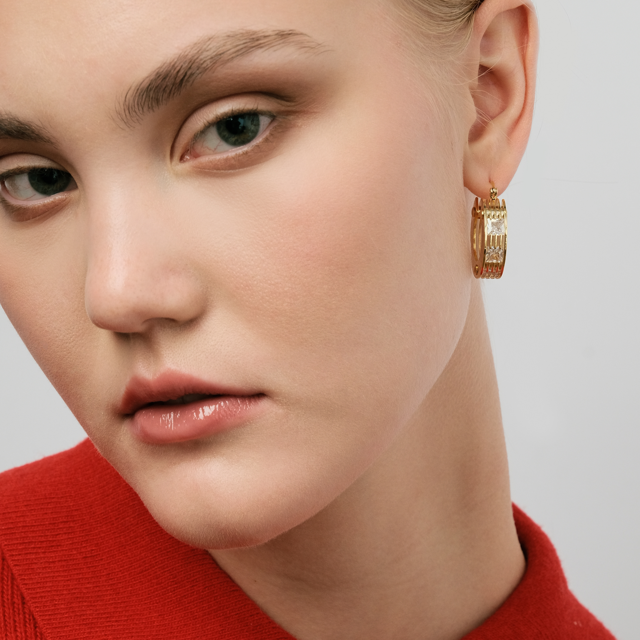 Golden round earrings made of several plates with crystals