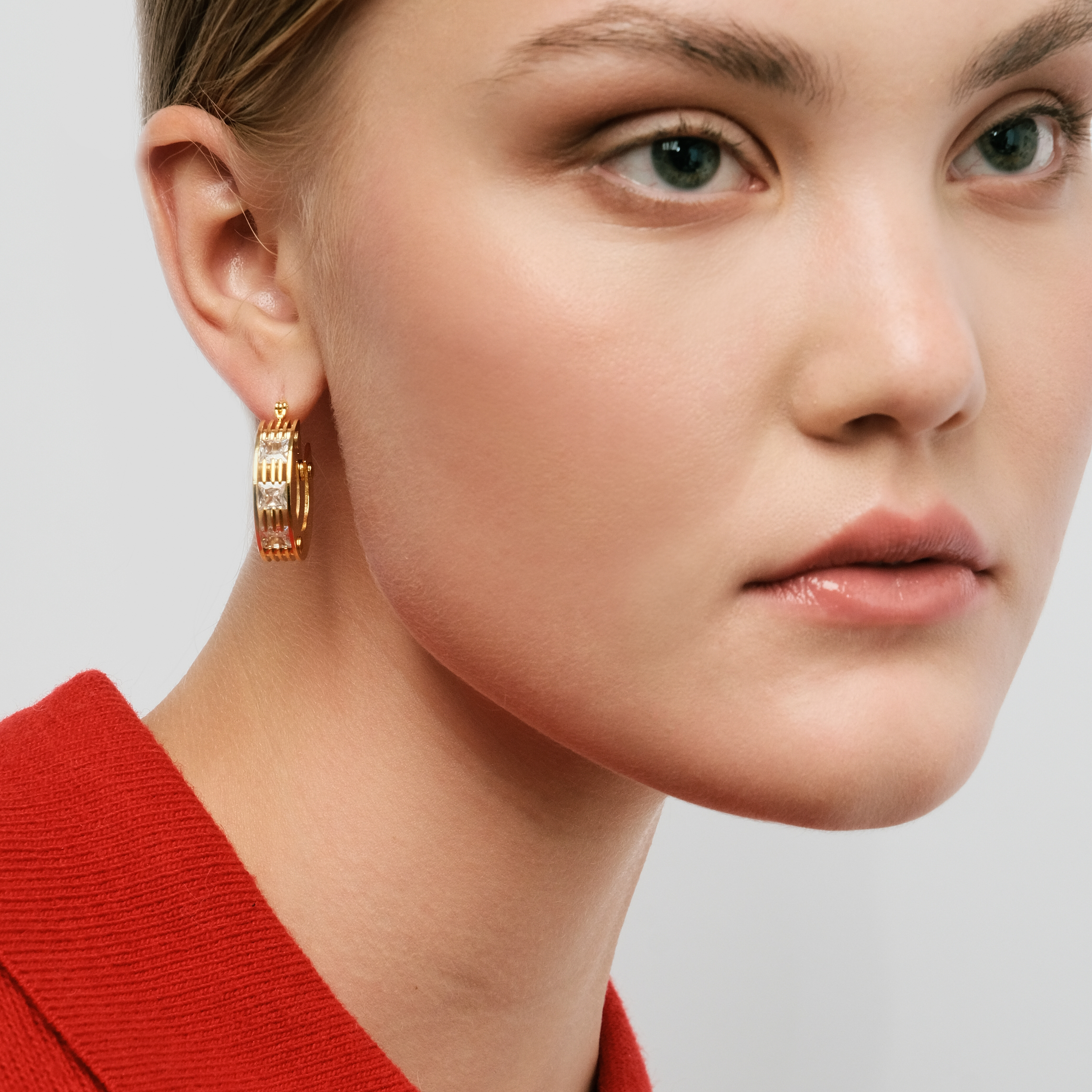 Golden round earrings made of several plates with crystals