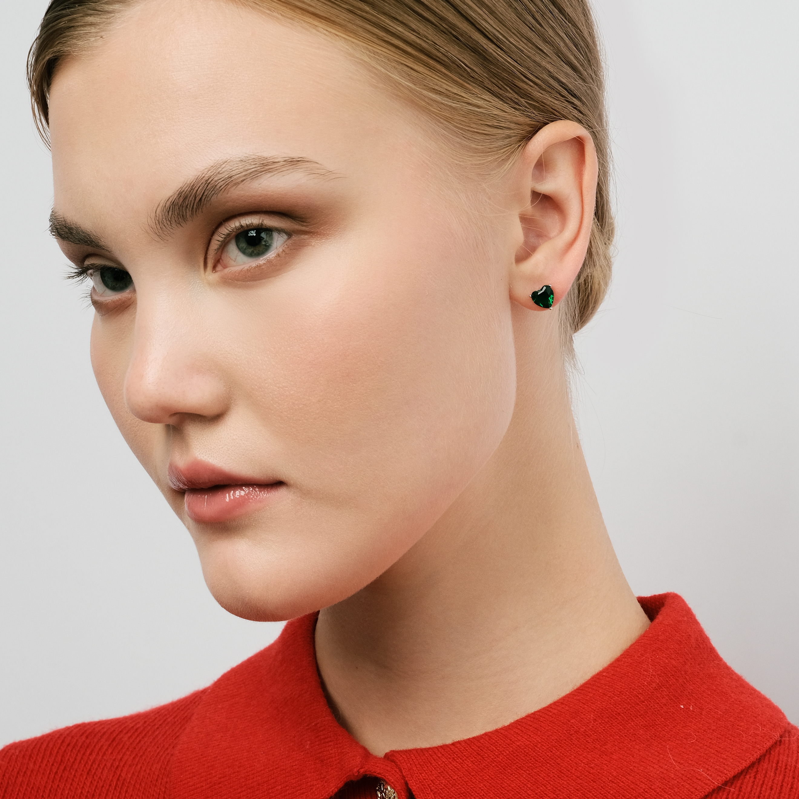 Silver earrings in the shape of a green heart