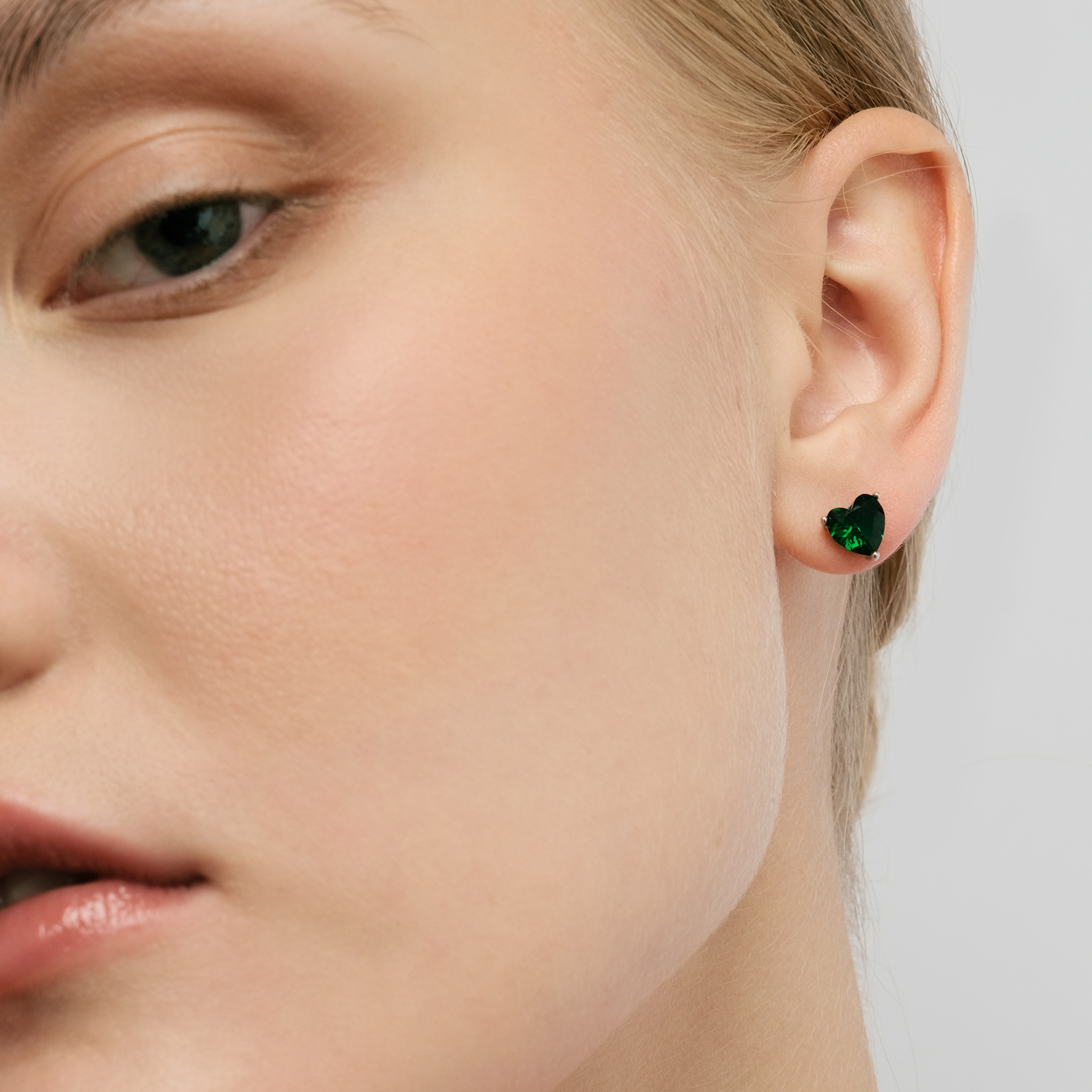 Silver earrings in the shape of a green heart
