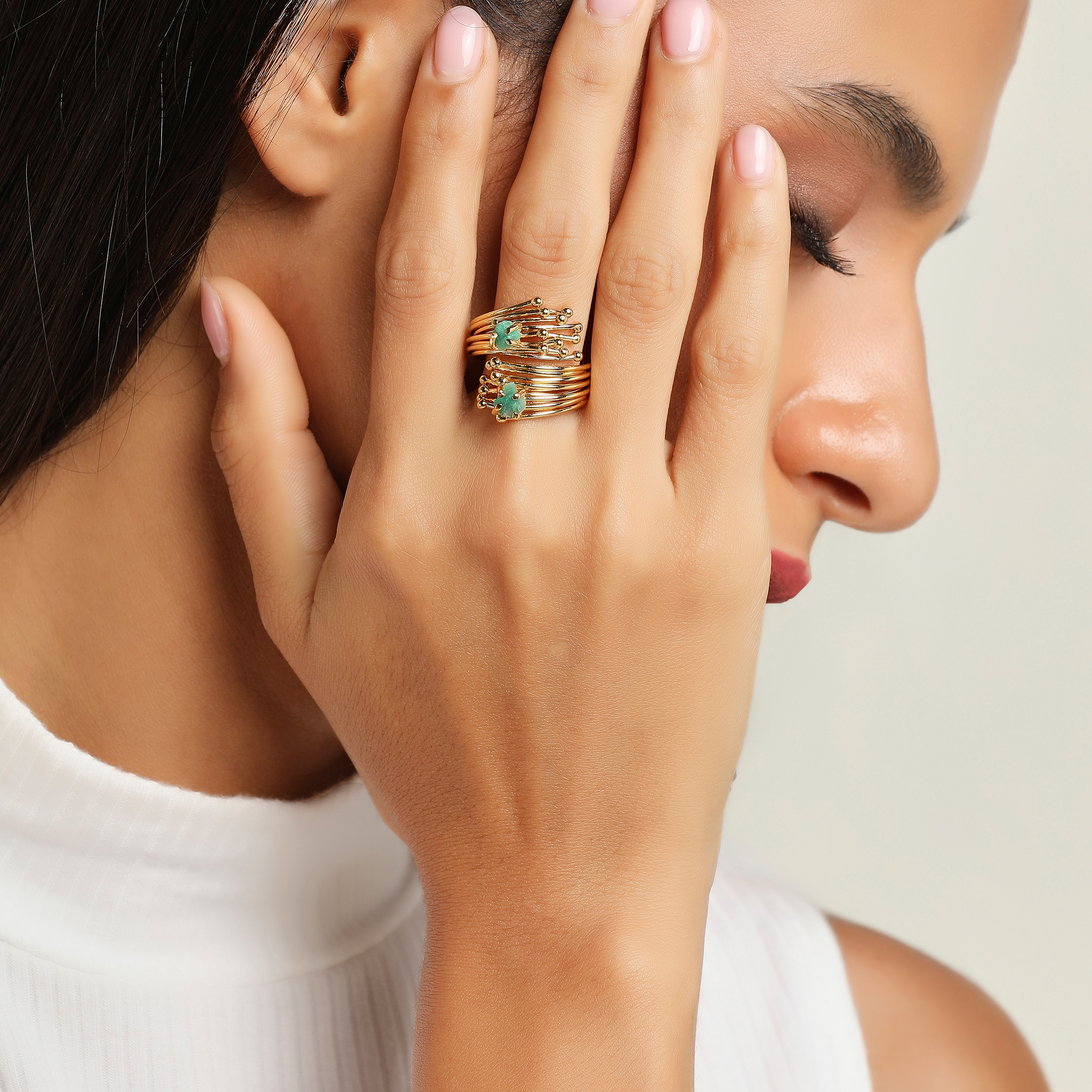 Gold-plated open ring made of threads with emeralds