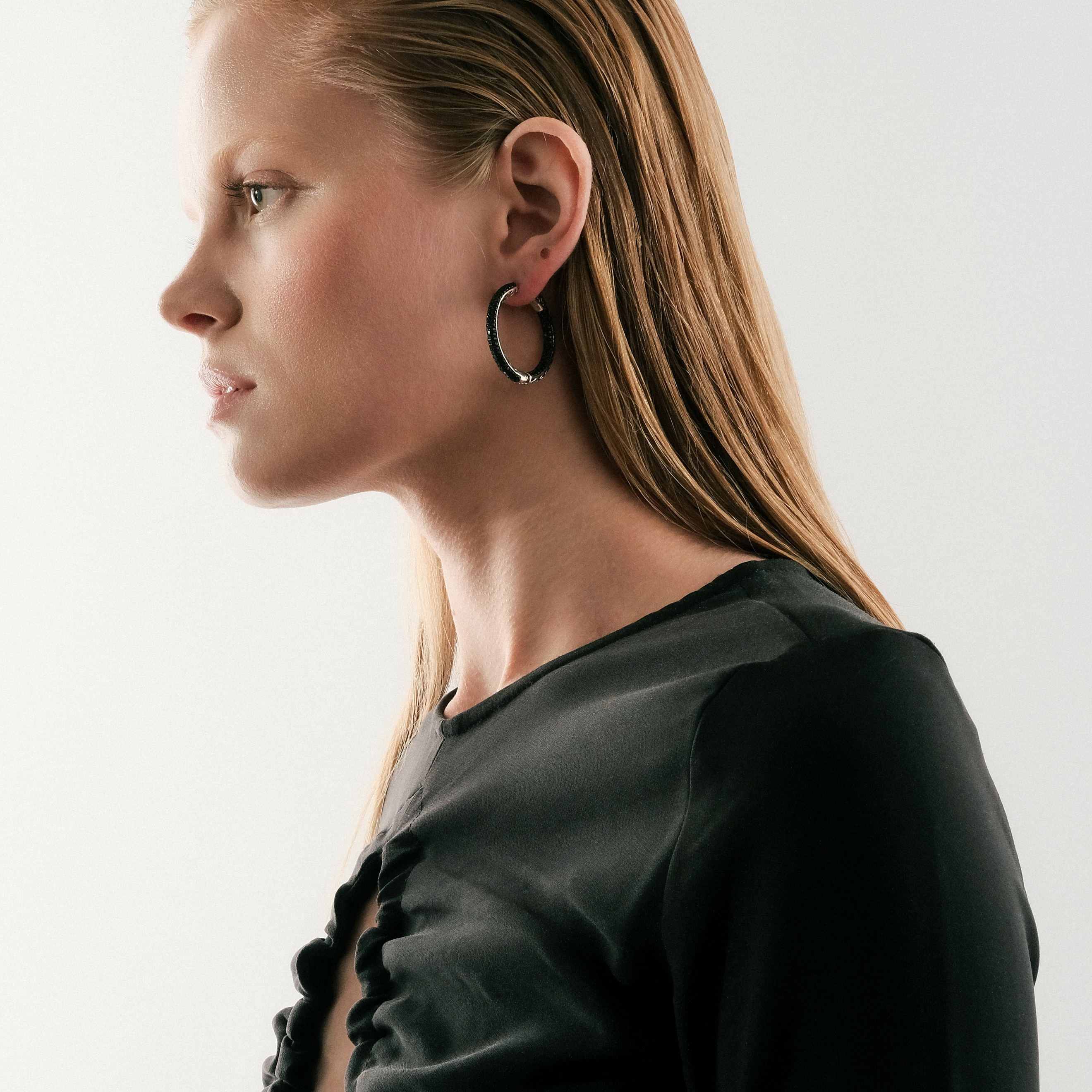 Large silver hoop earrings with black crystals