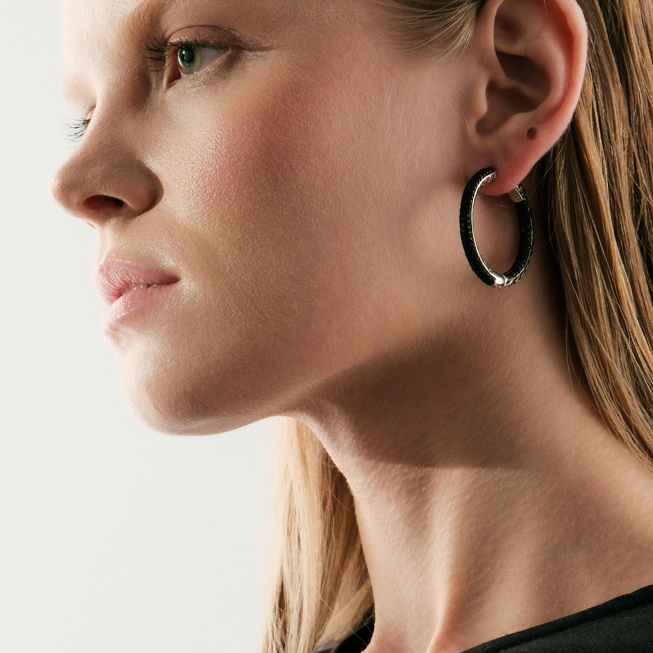 Large silver hoop earrings with black crystals